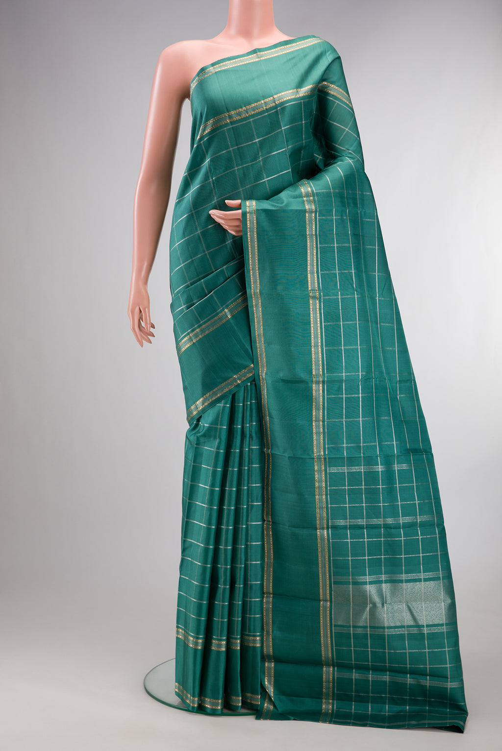 Pure Silk Teal Kanchipuram Saree with Checked design on the body and Zari Border.  displayed on a mannequin