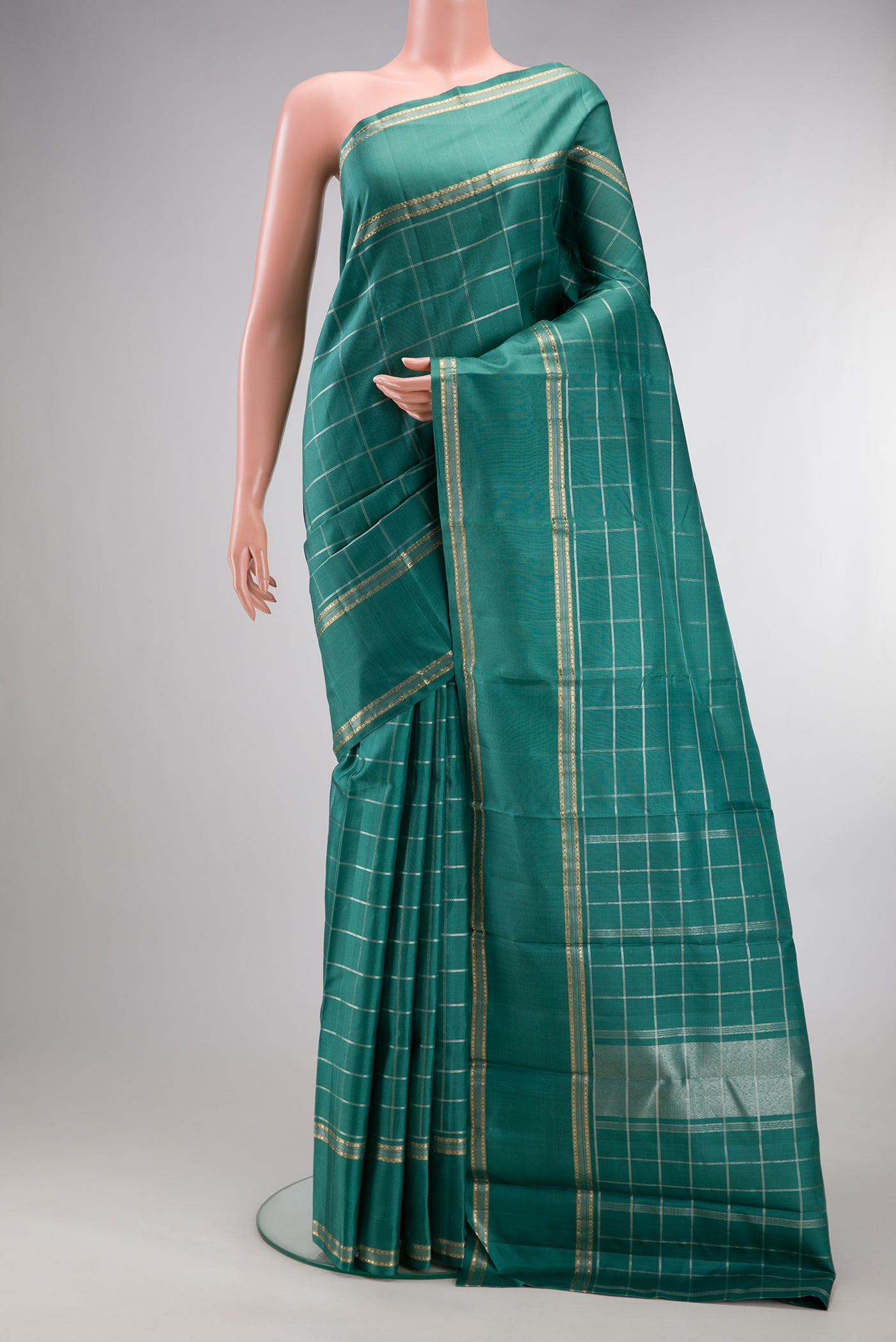 Pure Silk Teal Kanchipuram Saree with Checked design on the body and Zari Border.  displayed on a mannequin