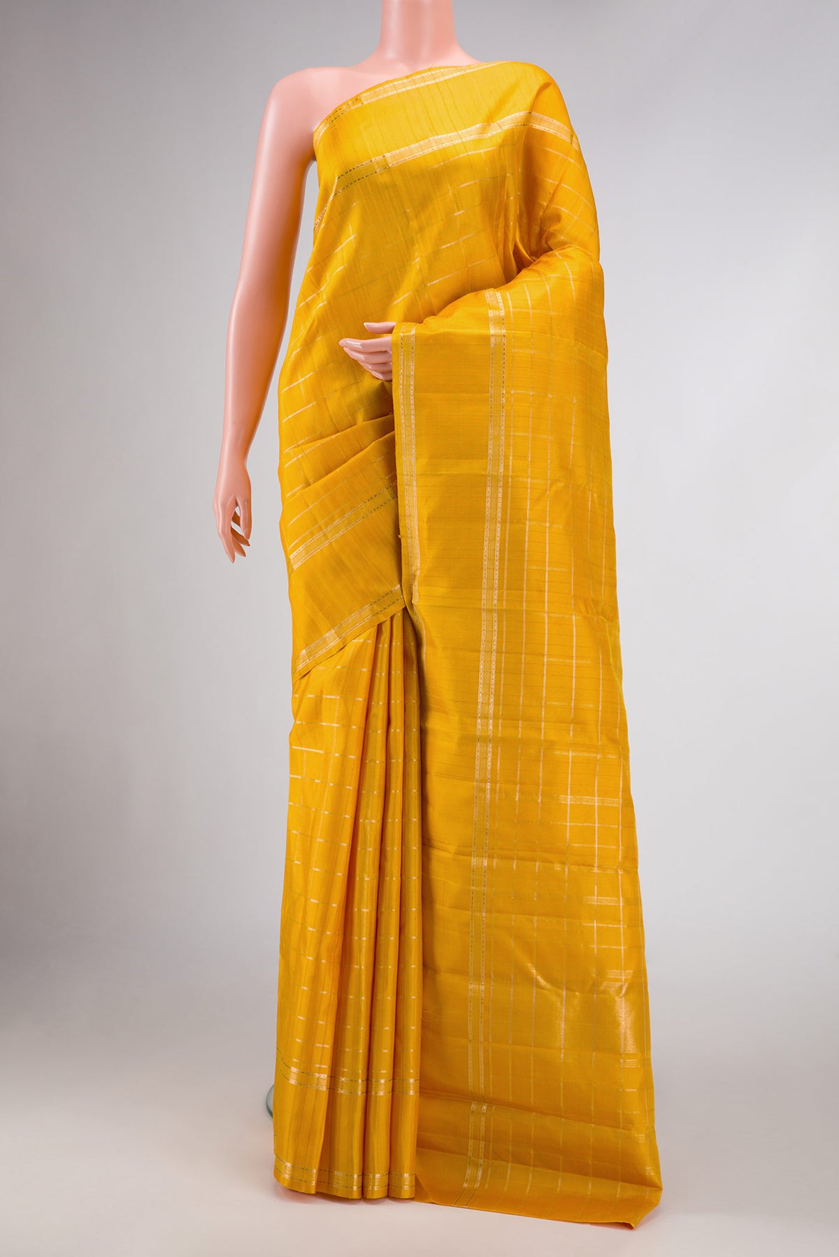 Mustard Dual Tone Kanchipuram Silk Saree with Checked design on the body and Zari Border.  displayed on a mannequin
