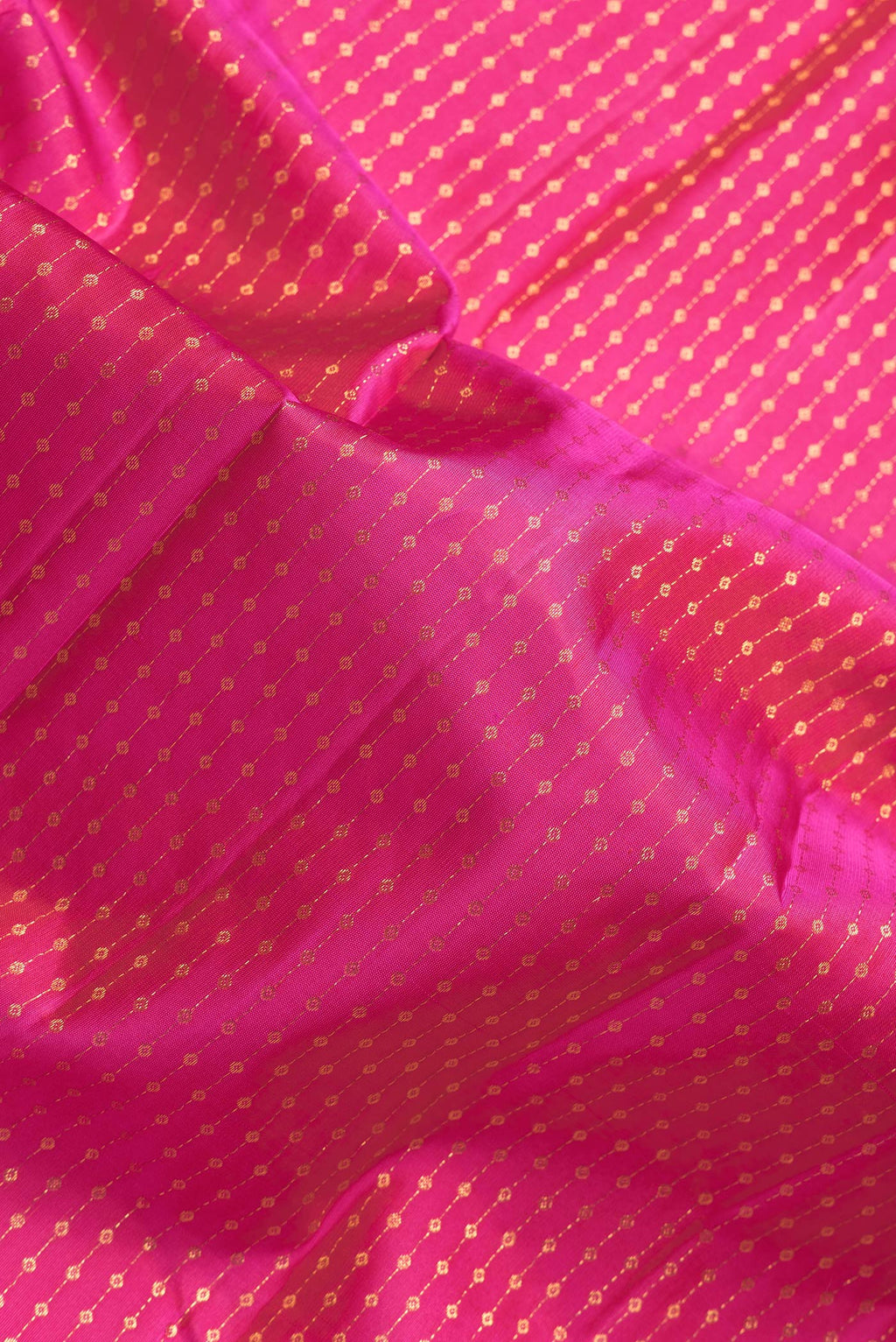 Close up of Dark Pink Dual Tone Kanchipuram Silk Saree with Zari Butta on the body and Thin Zari Line.  displaying folds