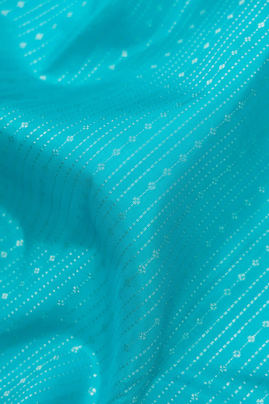 Close up of Light Blue Dual Tone Kanchipuram Silk Saree with Stripes on the body and Zari Border displaying folds