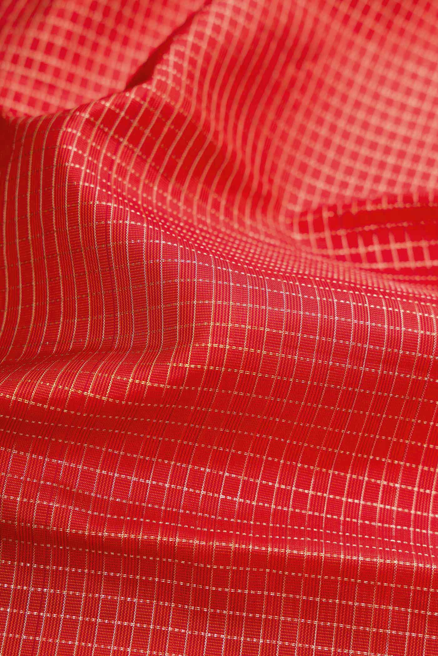Close up of Orange Dual Tone Kanchipuram Silk Saree with Checked design on the body and Zari Border.  displaying folds