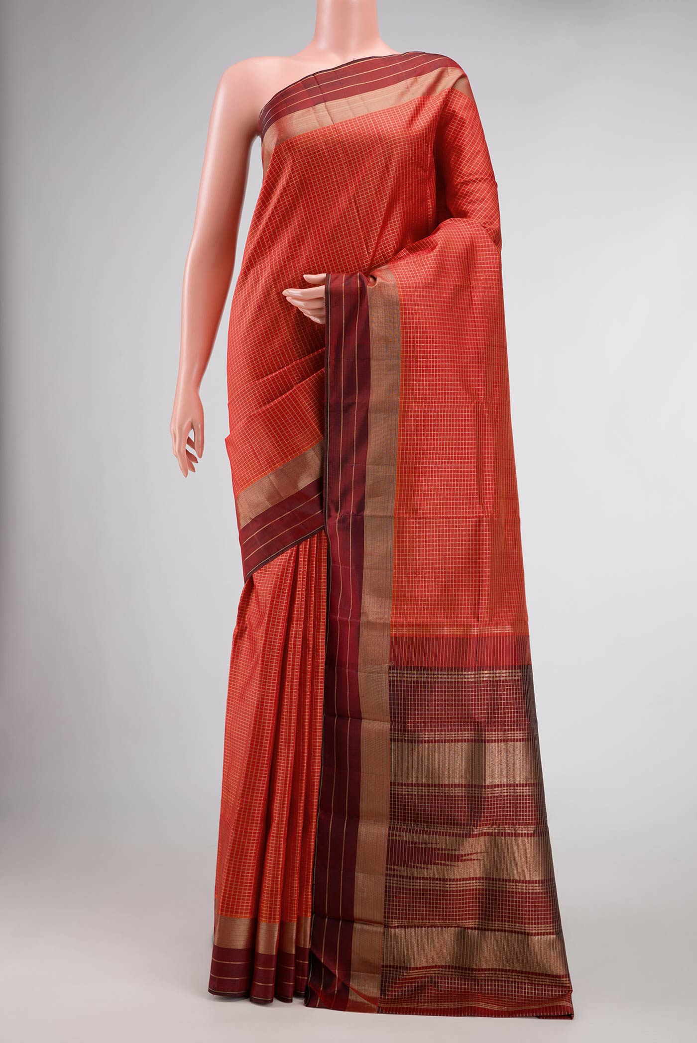 Orange Dual Tone Kanchipuram Silk Saree with Checked design on the body and Zari Border.  displayed on a mannequin