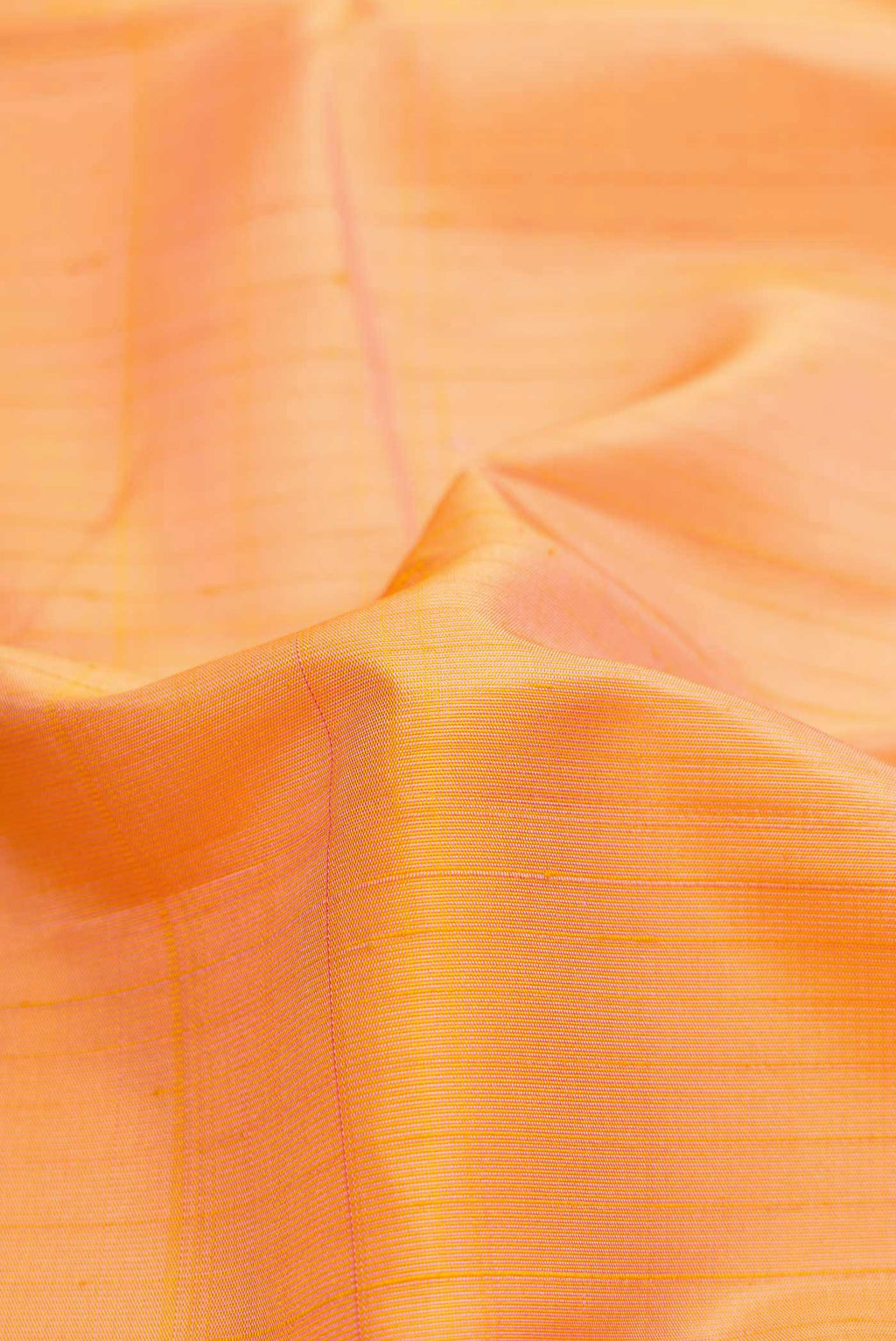 Close up of Golden Peach Dual Tone Kanchipuram Silk Saree with Stripes on the body and Zari Border.  displaying folds