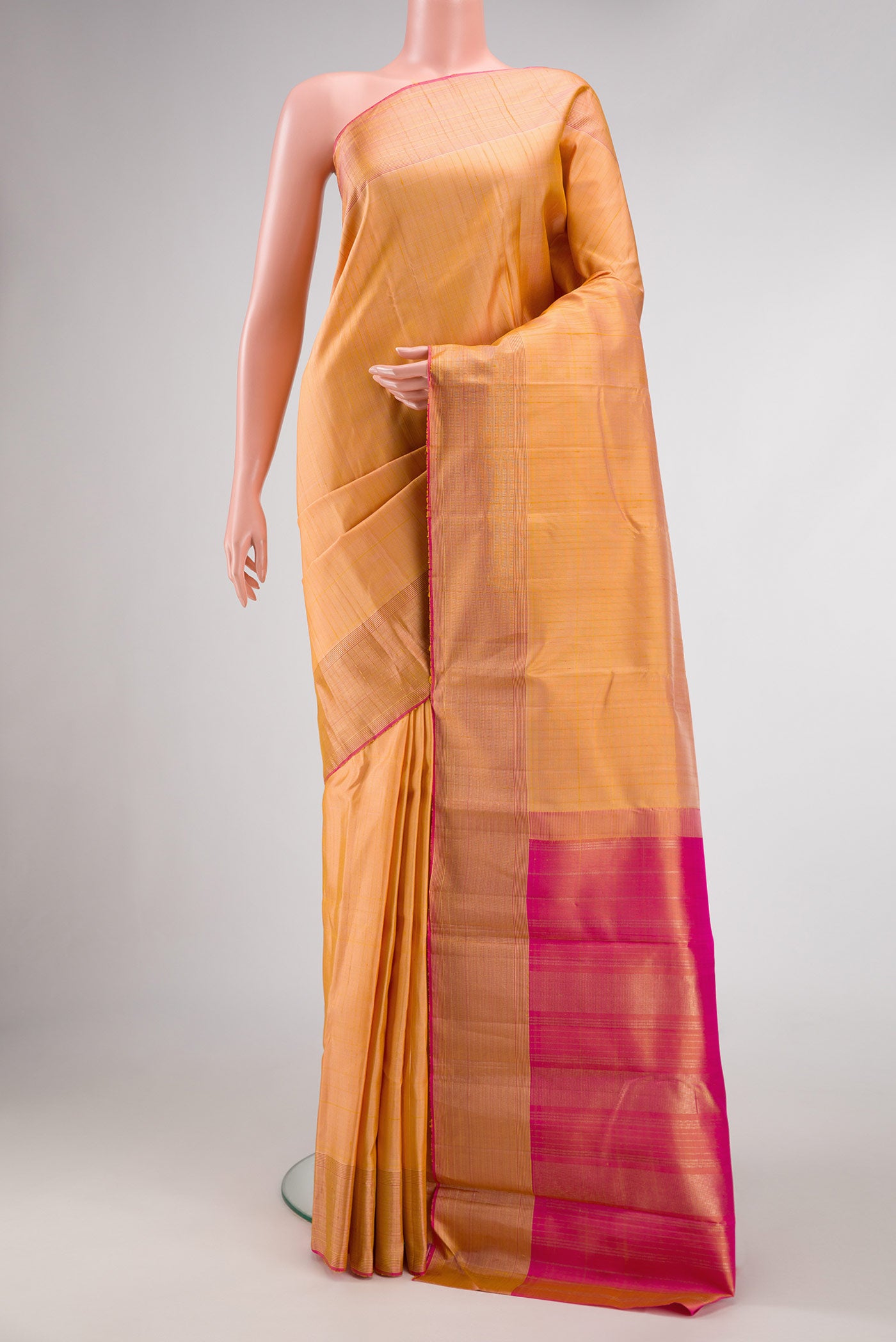 Golden Peach Dual Tone Kanchipuram Silk Saree with Stripes on the body and Zari Border.  displayed on a mannequin