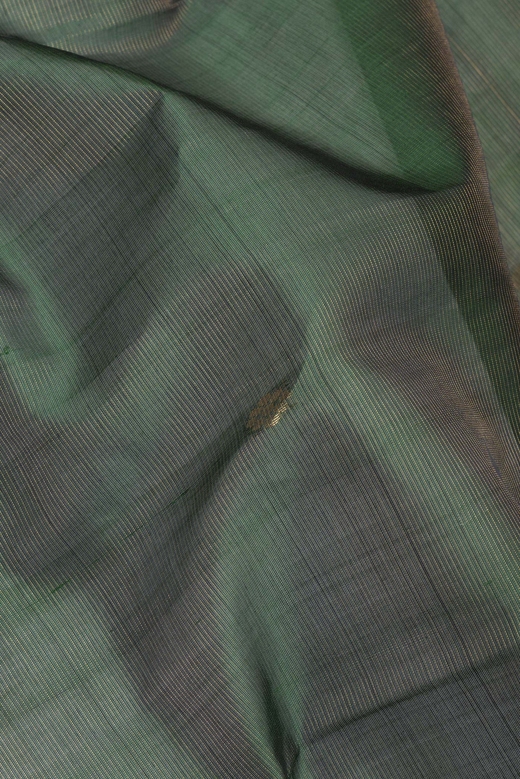 Close up of Bottle Green Silk Cotton Saree with Zari Butta on the body and Zari Border.  displaying folds