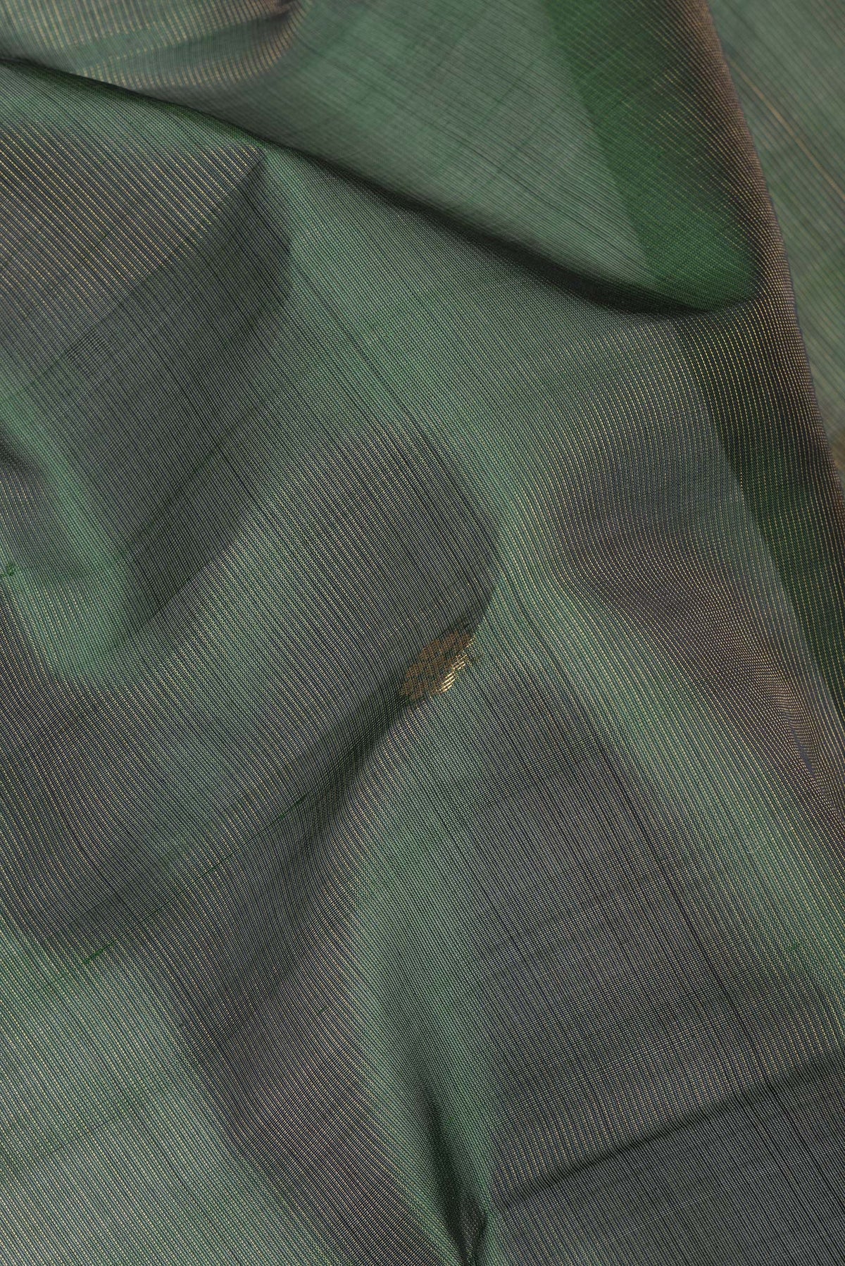 Close up of Bottle Green Silk Cotton Saree with Zari Butta on the body and Zari Border.  displaying folds