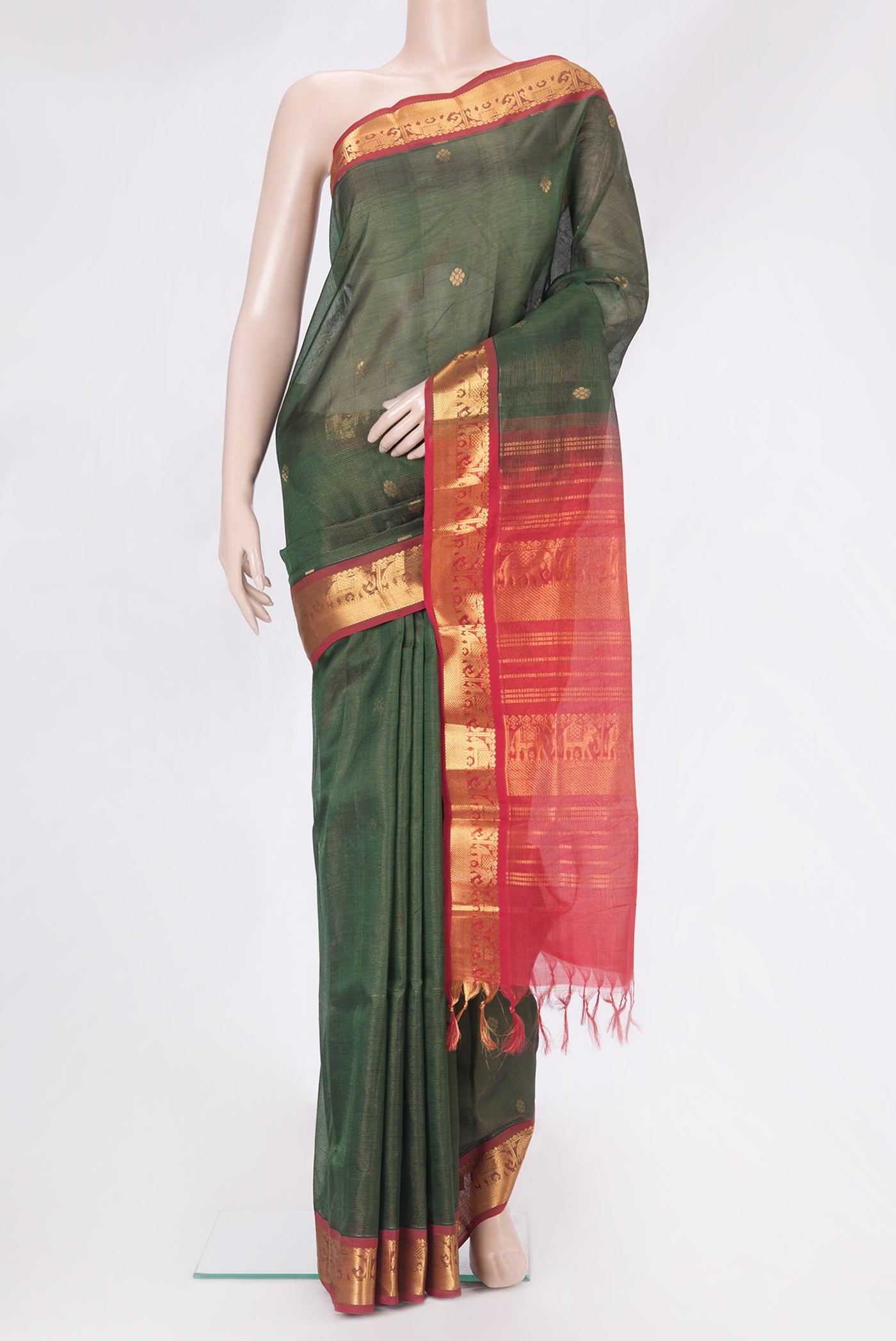 Bottle Green Silk Cotton Saree with Zari Butta on the body and Zari Border.  displayed on a mannequin
