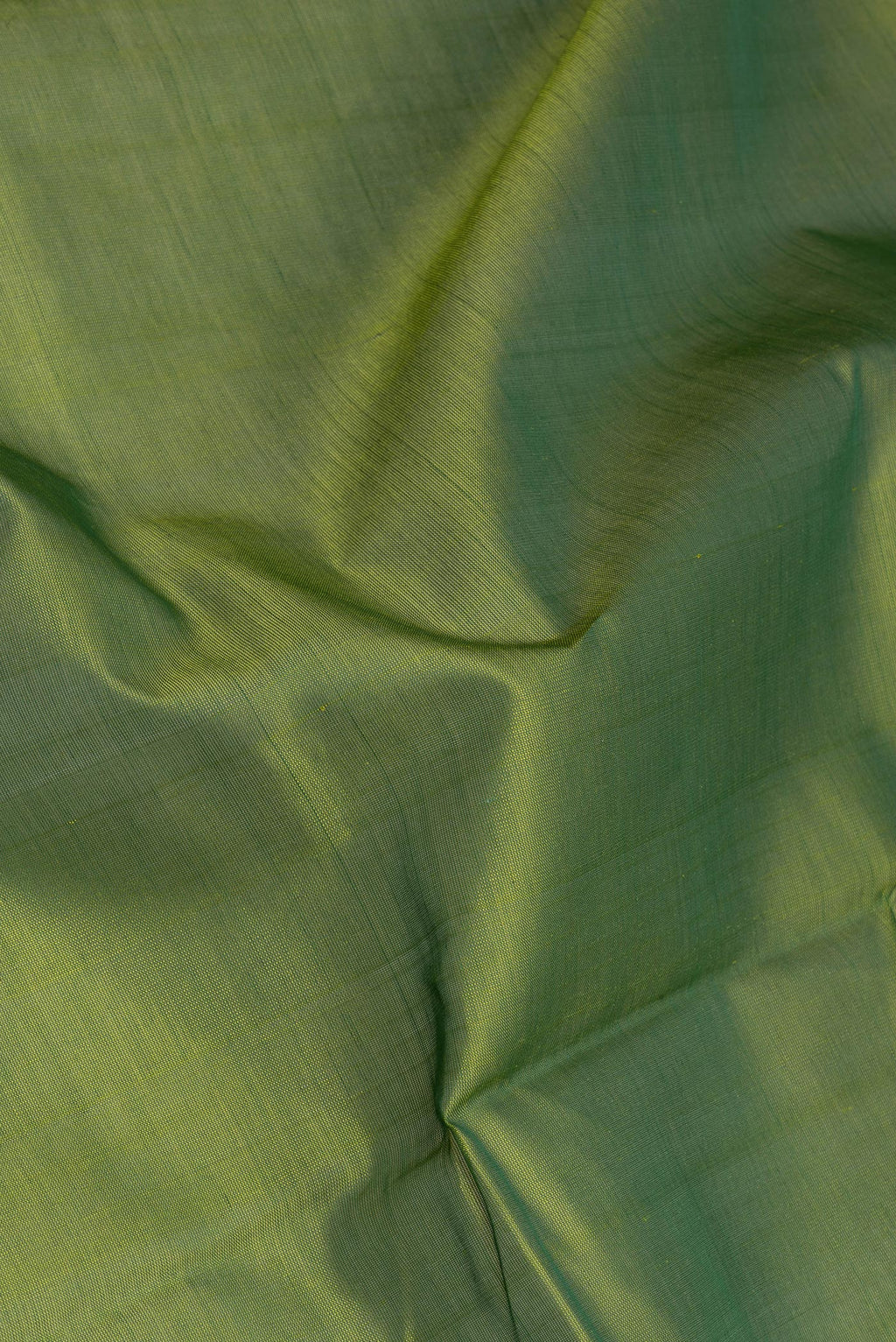 Close up of Green Silk Cotton Saree with Plain Body and Zari Border.  displaying folds