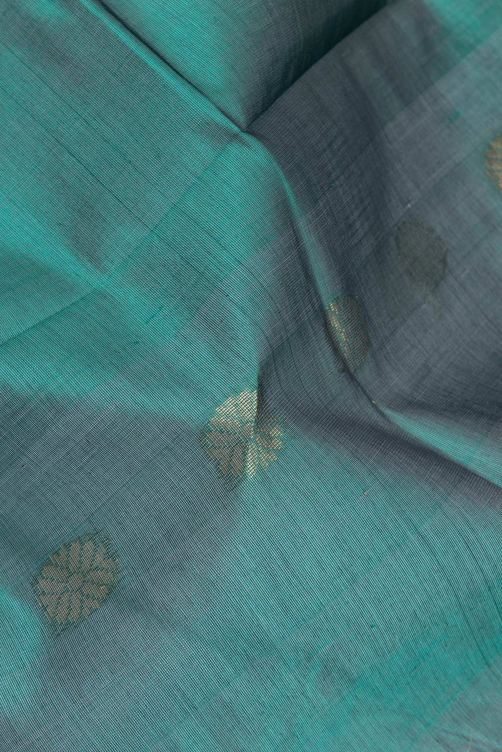 Close up of Green Silk Cotton Saree with Zari Butta on the body and Zari Border.  displaying folds
