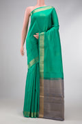 Green Dual Tone Soft Silk Saree with Zari Butta on the body and Zari Border.  displayed on a mannequin