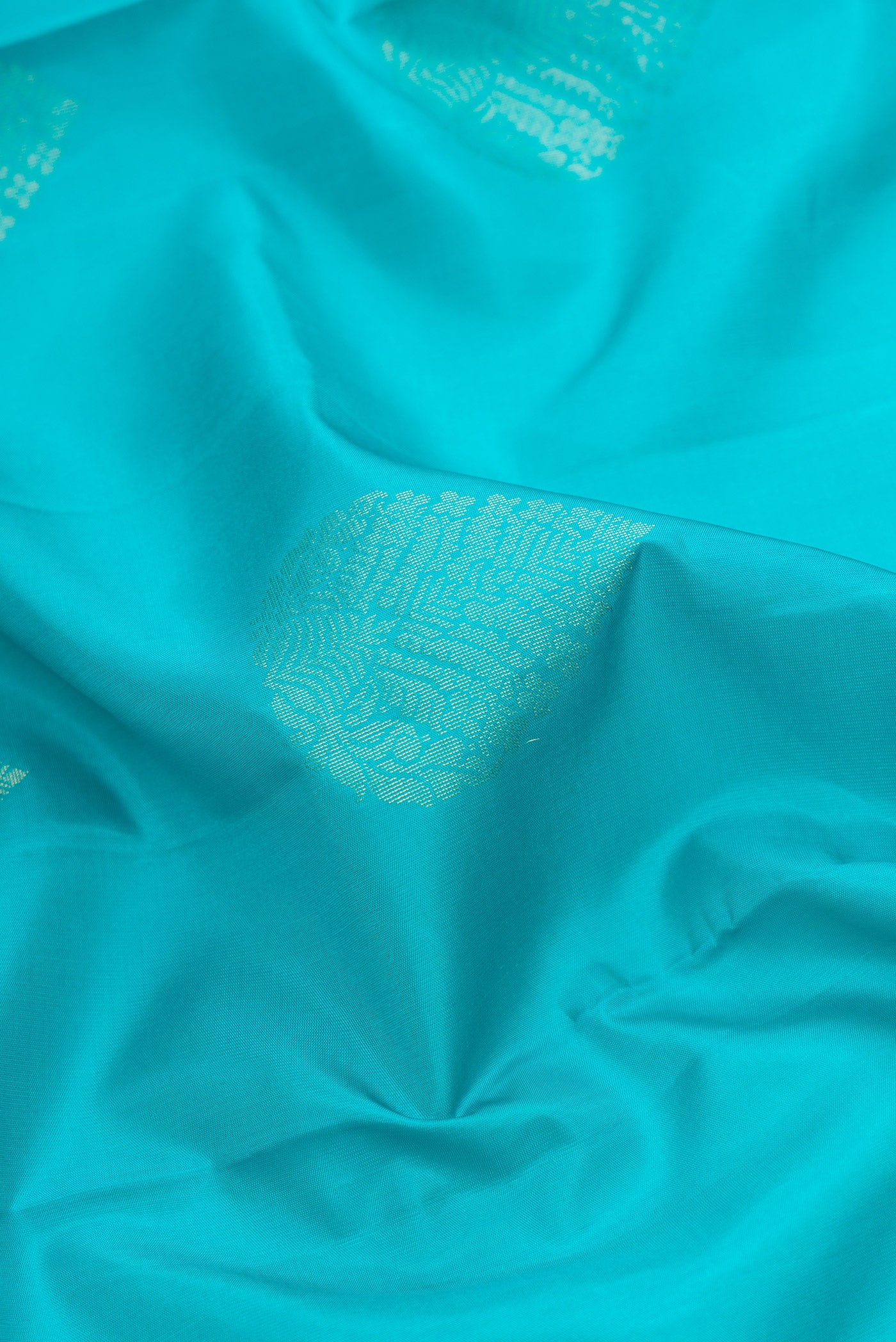 Close up of Sky Blue Dual Tone Soft Silk Saree with Zari Butta on the body and Zari Border.  displaying folds