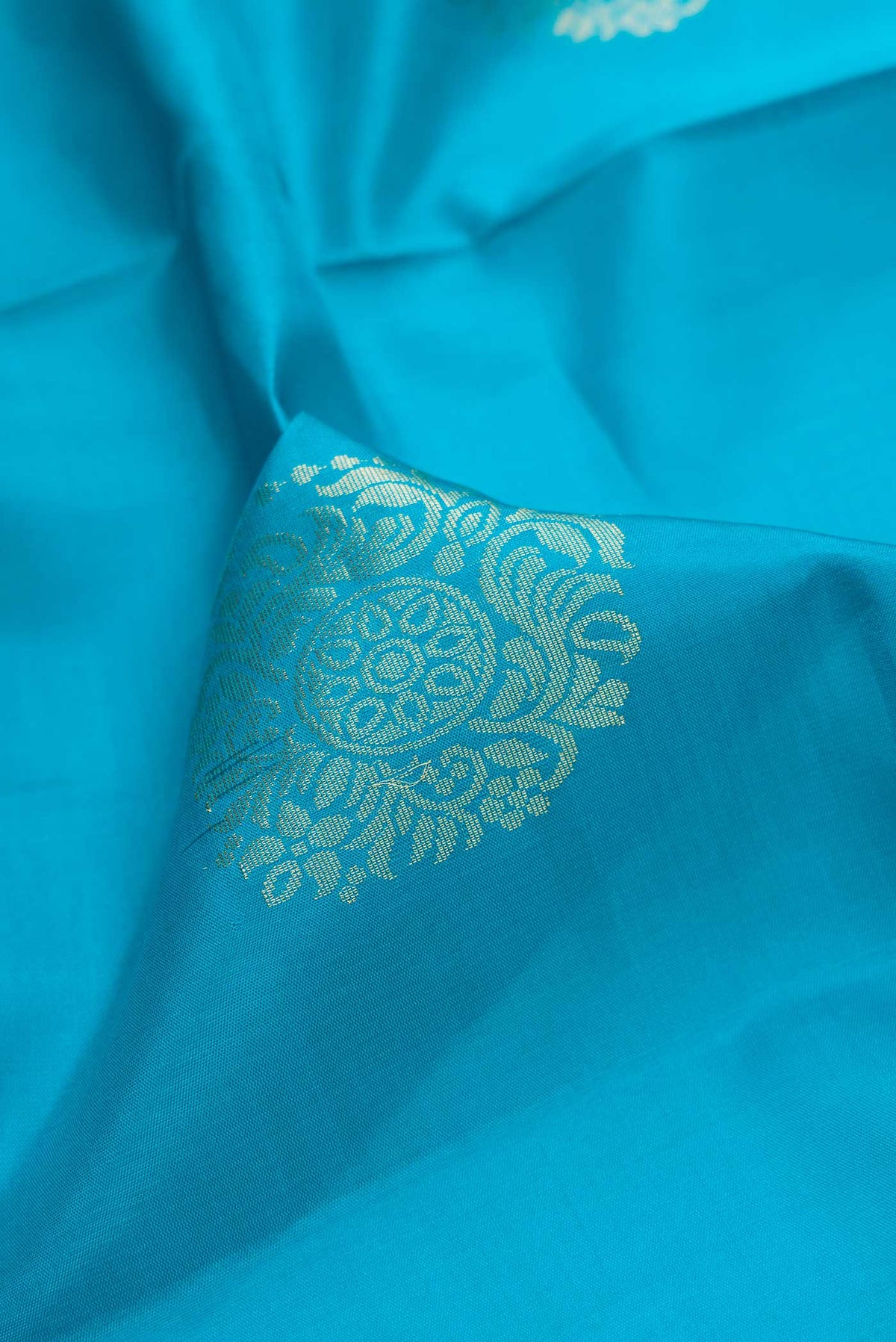 Close up of Sky Blue Dual Tone Soft Silk Saree with Zari Butta on the body and Zari Border.  displaying folds