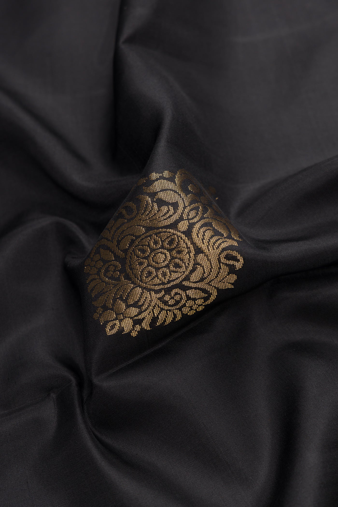 Close up of Black Dual Tone Soft Silk Saree with Zari Butta on the body and Zari Border.  displaying folds
