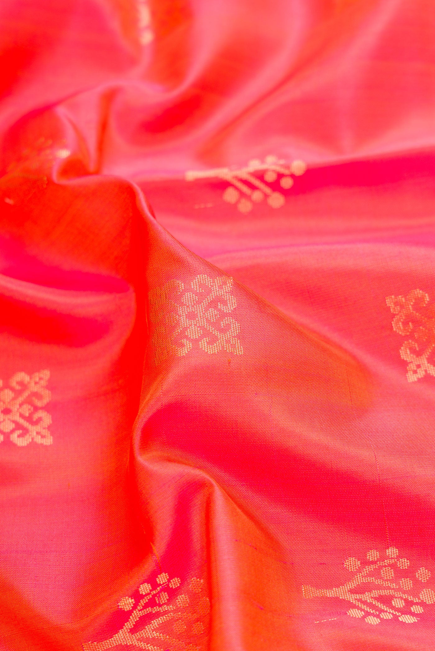Close up of Orange Dual Tone Soft Silk Saree with Zari Butta on the body and Zari Border.  displaying folds