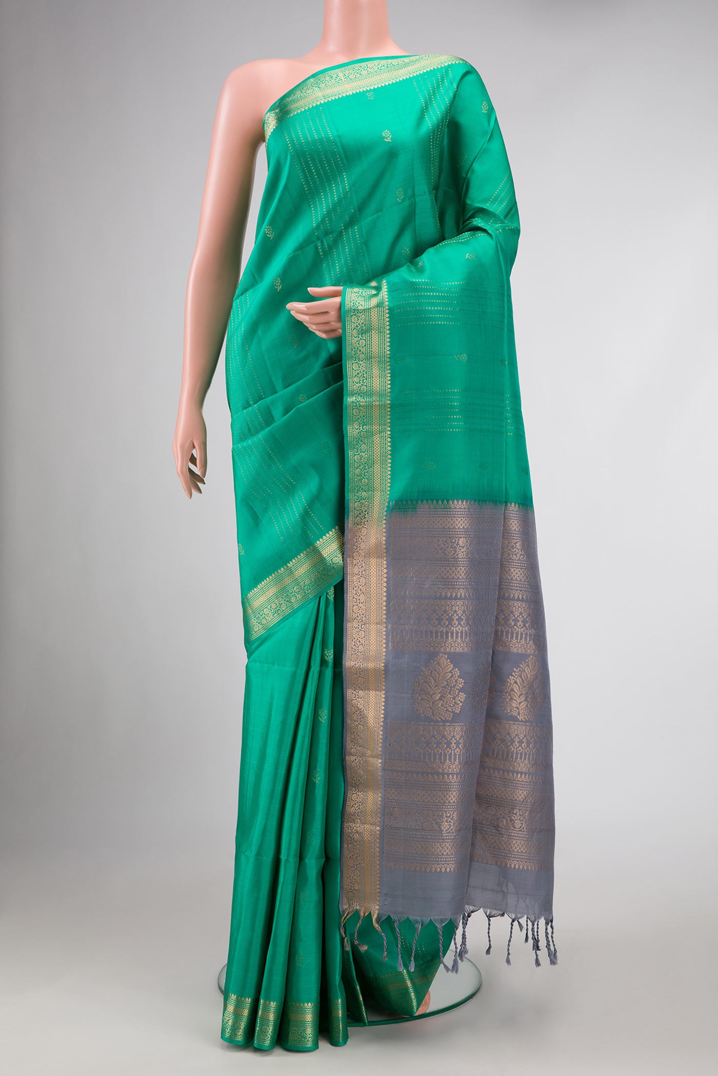 Green Dual Tone Soft Silk Saree with Zari Butta on the body and Zari Border.  displayed on a mannequin