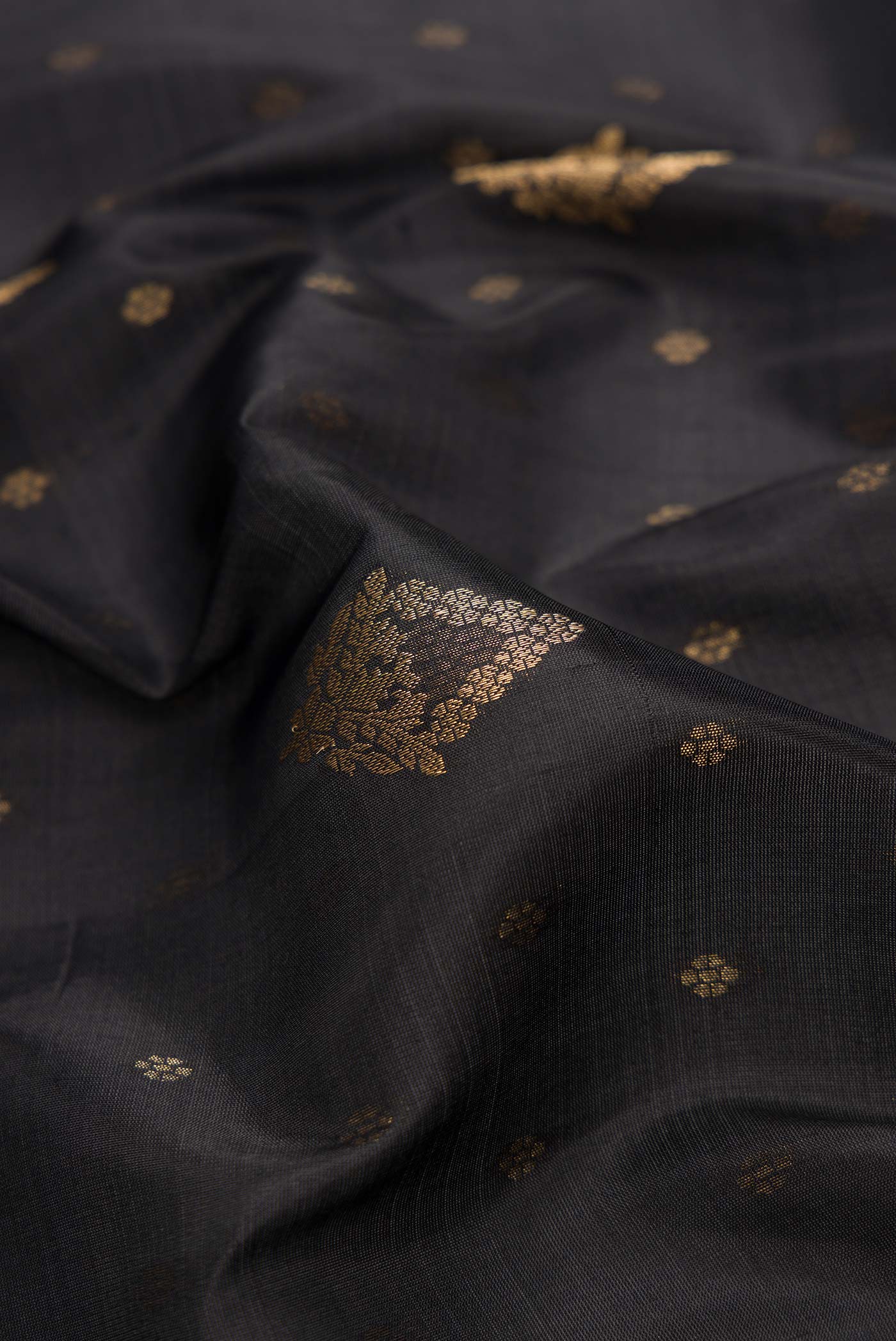 Close up of Black Dual Tone Soft Silk Saree with Zari Butta on the body and Zari Border.  displaying folds