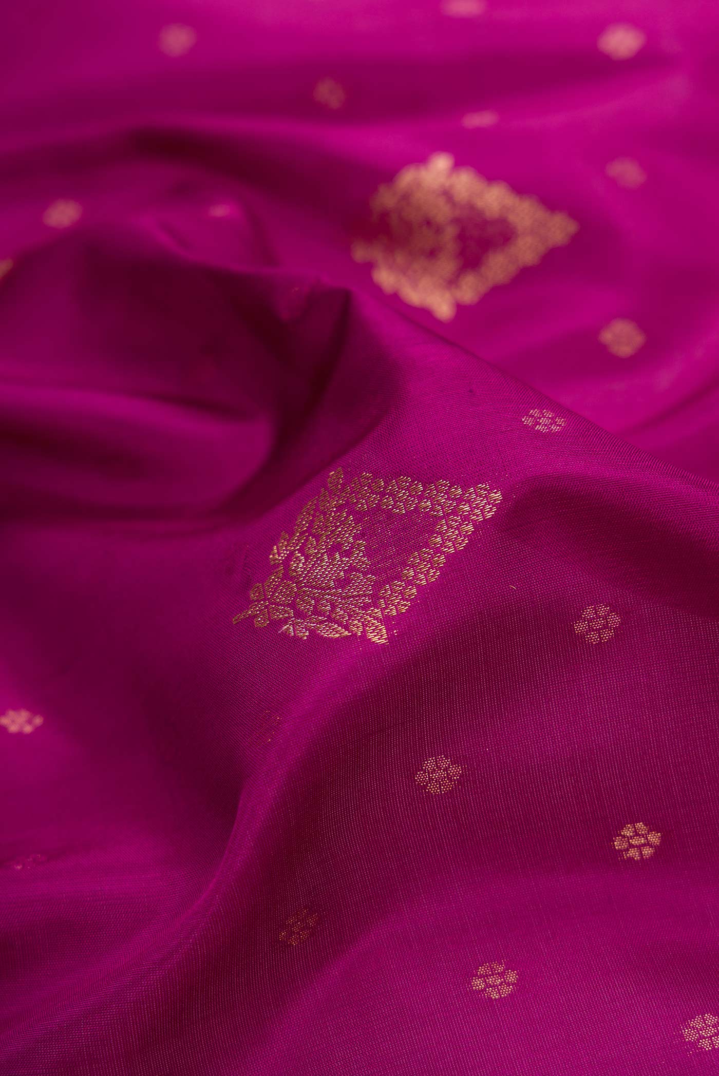 Close up of Magenta Dual Tone Soft Silk Saree with Zari Butta on the body and Zari Border.  displaying folds