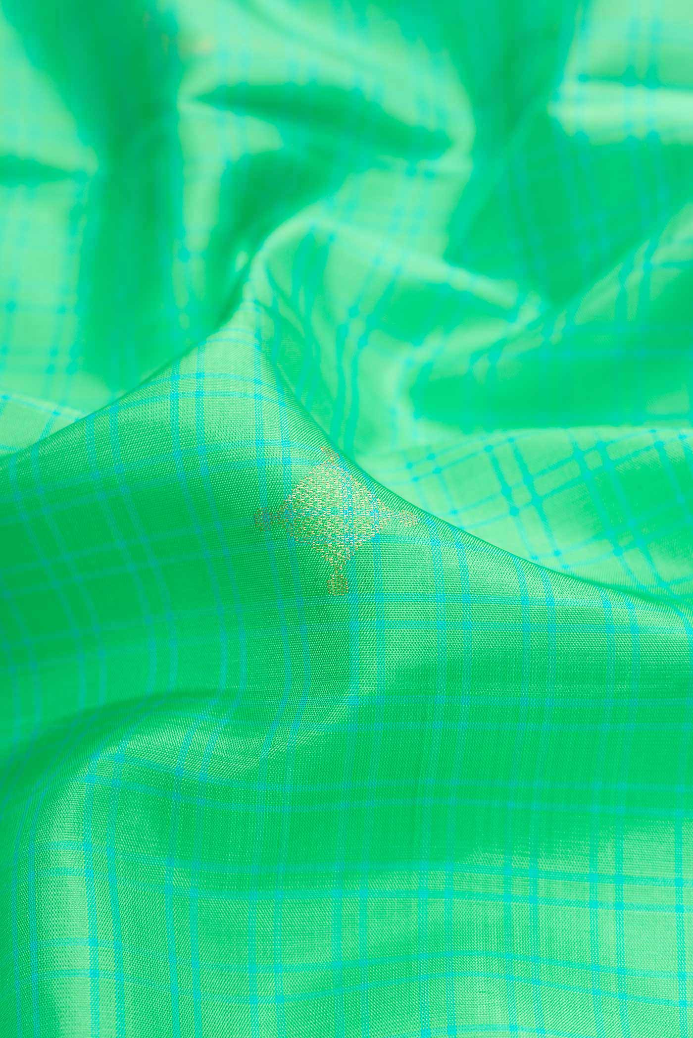 Close up of Parrot Green Dual Tone Soft Silk Saree with Zari Butta on the body and Zari Border.  displaying folds