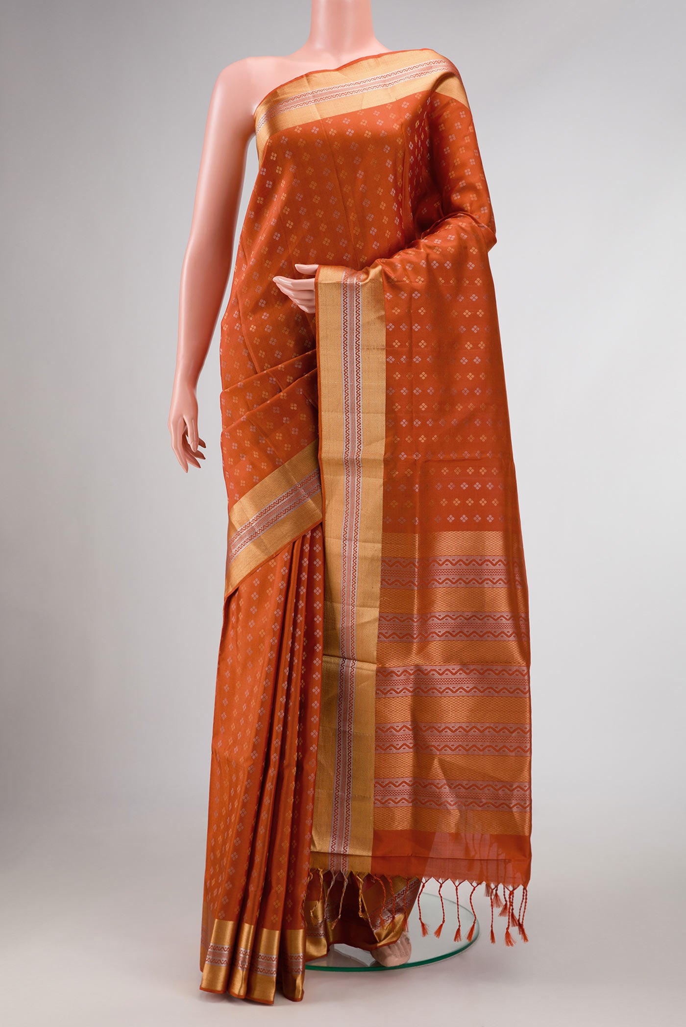 Orange Dual Tone Soft Silk Saree with Zari Butta on the body and Zari Border displayed on a mannequin