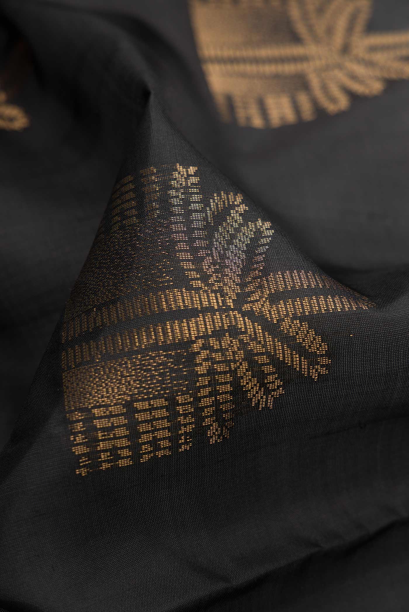 Close up of Black Dual Tone Soft Silk Saree with Zari Butta on the body and Without Border.  displaying folds