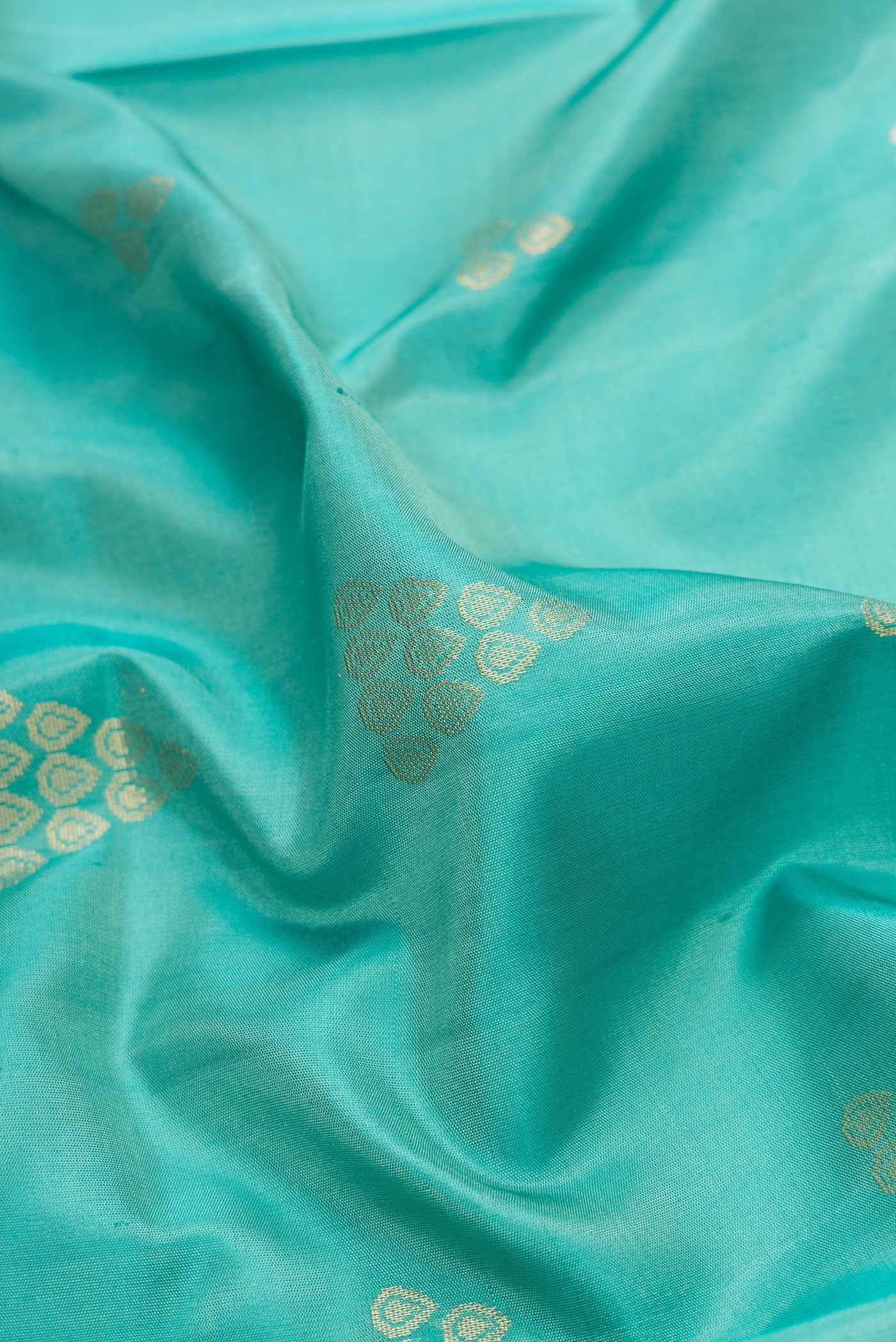 Close up of Sky Blue Dual Tone Soft Silk Saree with Zari Butta on the body and Zari Border.  displaying folds