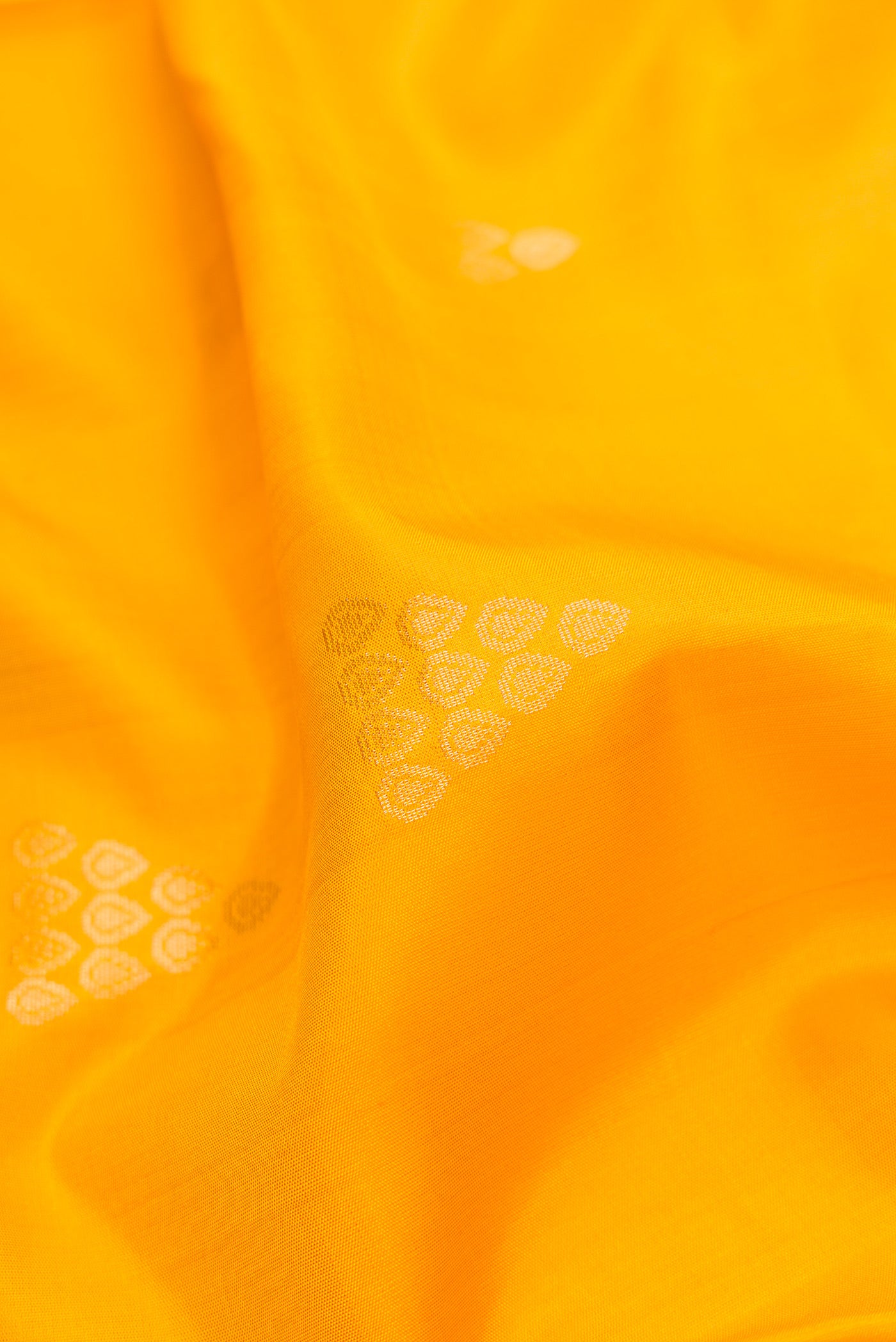 Close up of Yellow Dual Tone Soft Silk Saree with Zari Butta on the body and Zari Border.  displaying folds