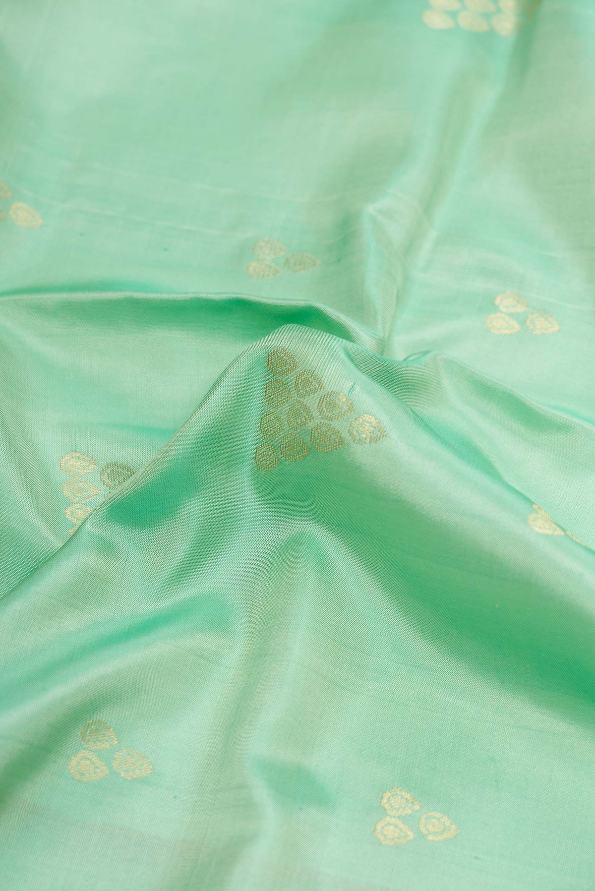 Close up of Sea Green Dual Tone Soft Silk Saree with Zari Butta on the body and Zari Border displaying folds