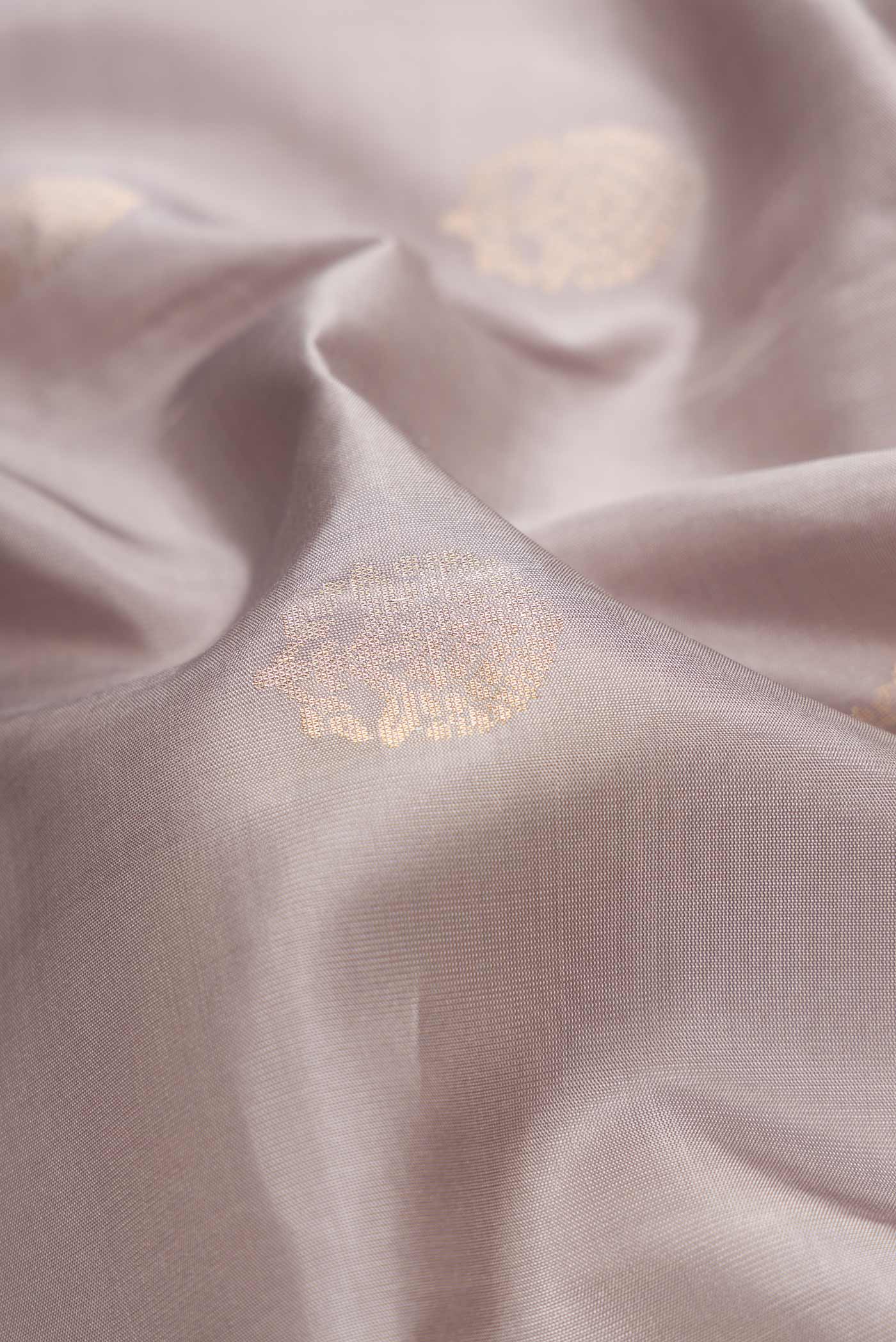 Close up of Grey Dual Tone Soft Silk Saree with Zari Butta on the body and Zari Border.  displaying folds