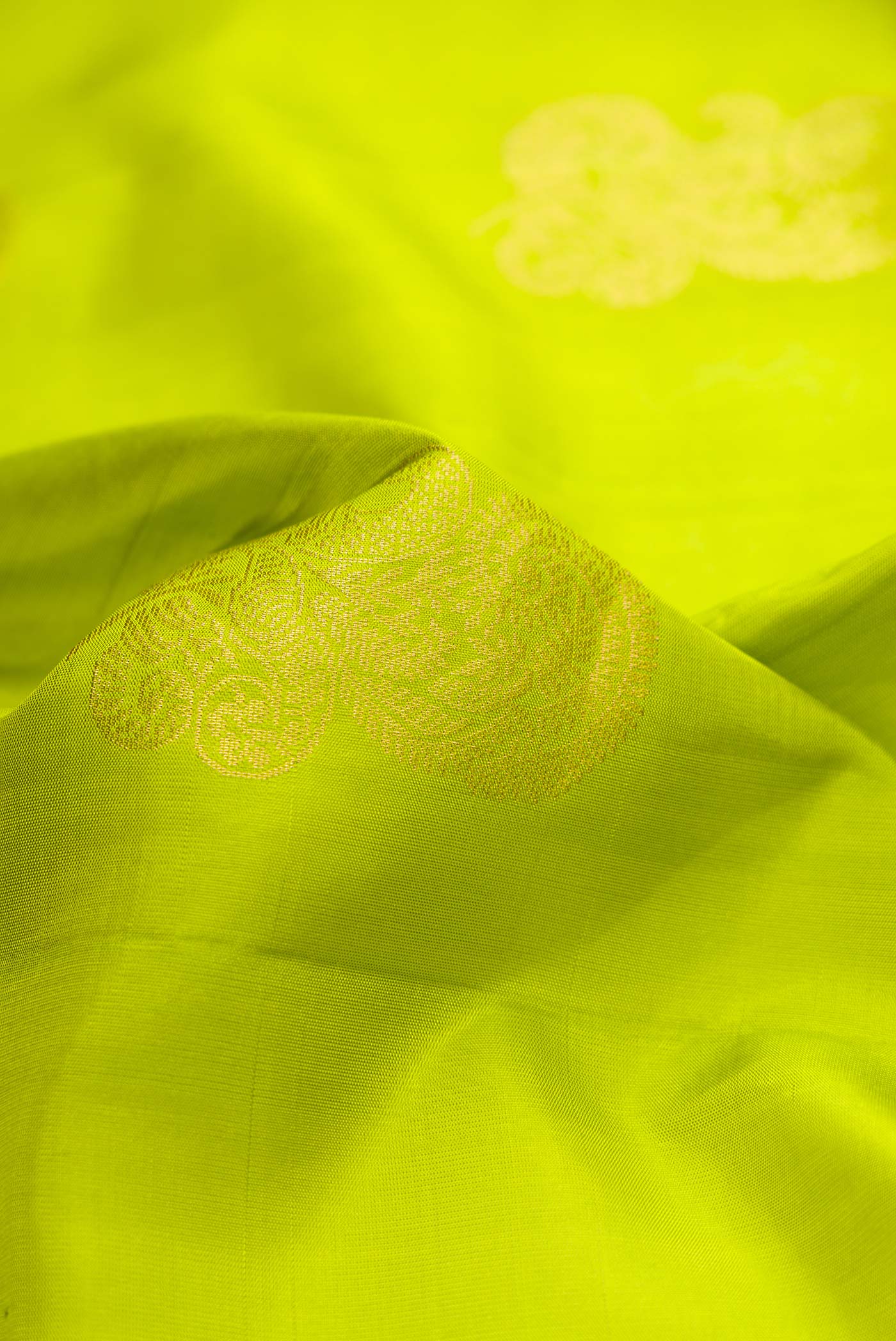 Close up of Parrot Green Dual Tone Soft Silk Saree with Zari Butta on the body and Zari Border.  displaying folds