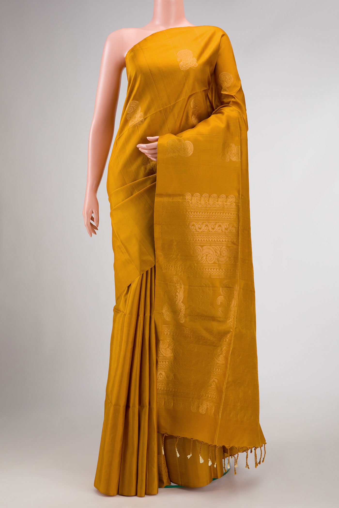 Mustard Dual Tone Soft Silk Saree with Zari Butta on the body and Without Border.  displayed on a mannequin