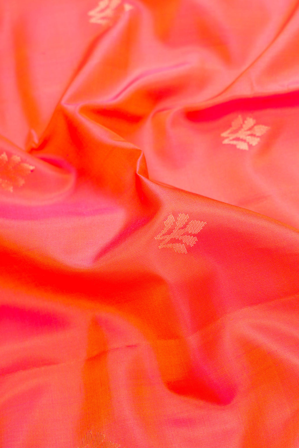 Close up of Orange Dual Tone Soft Silk Saree with Zari Butta on the body and Zari Border.  displaying folds
