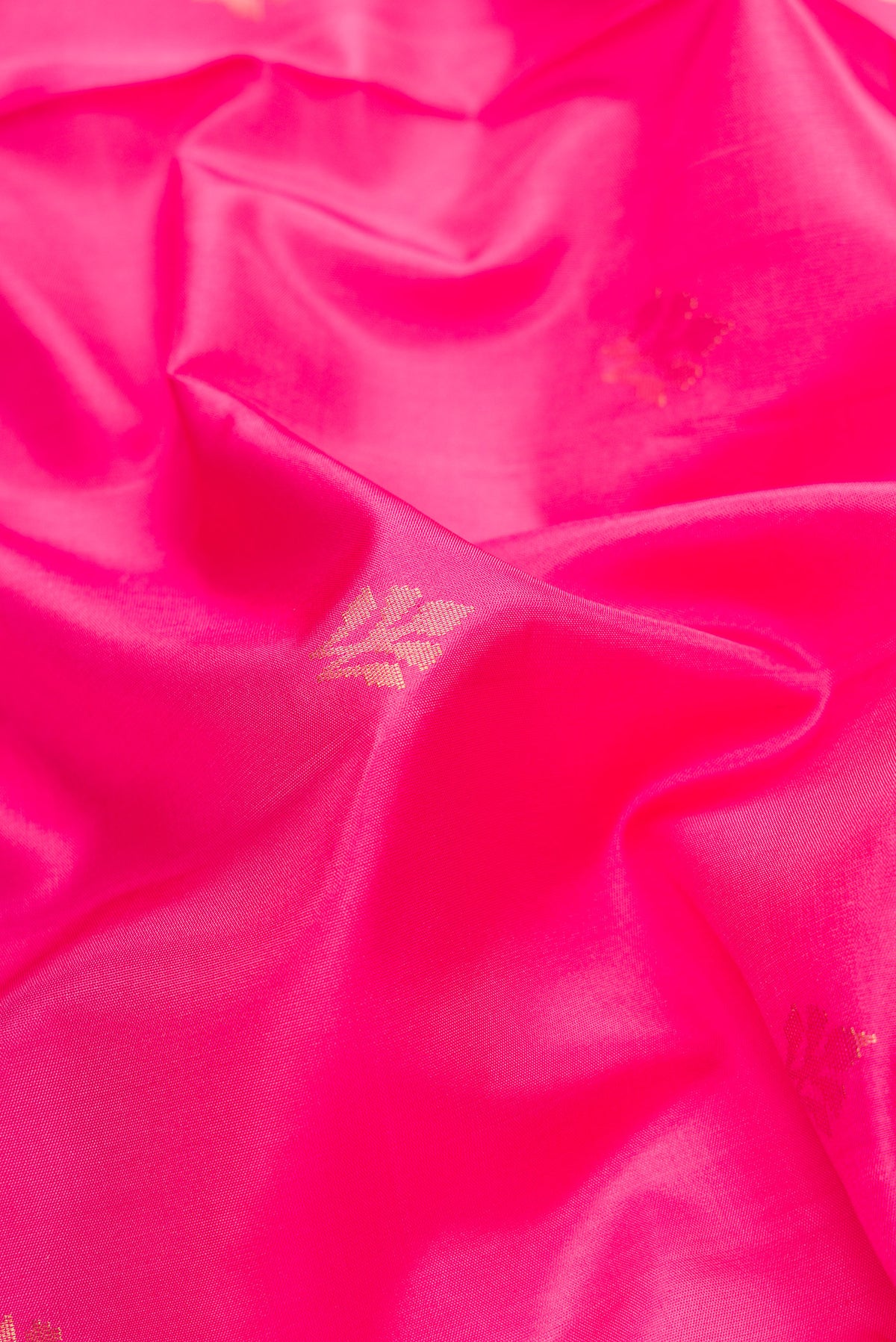 Close up of Pink Dual Tone Soft Silk Saree with Zari Butta on the body and Zari Border.  displaying folds