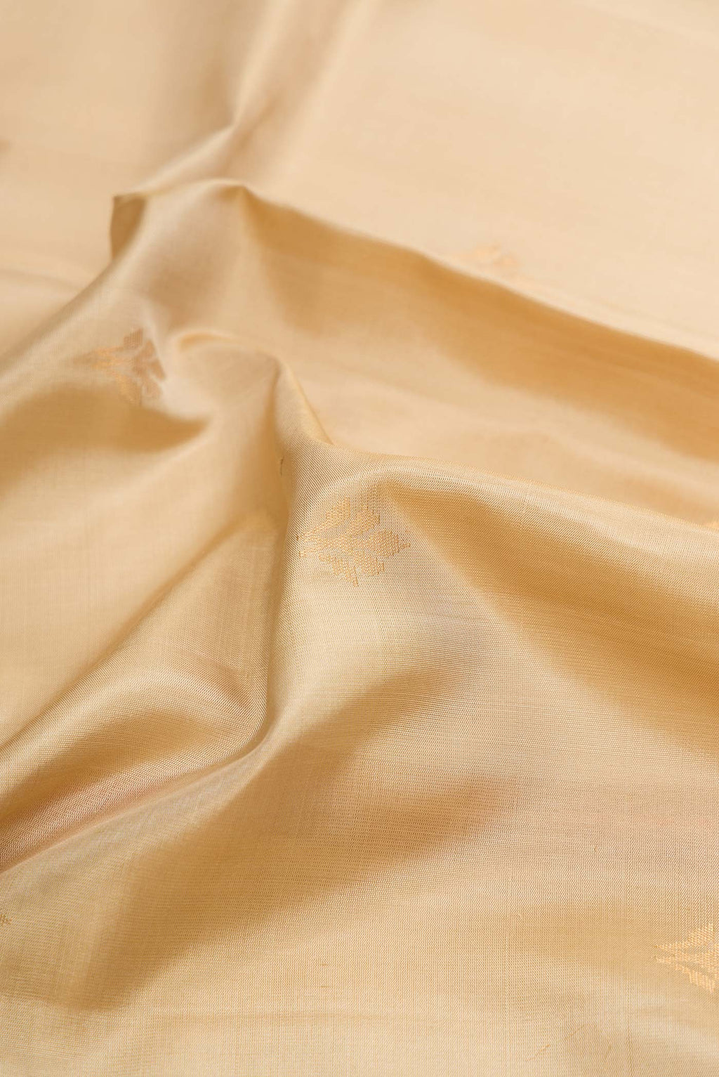 Close up of Beige Dual Tone Soft Silk Saree with Zari Butta on the body and Zari Border displaying folds