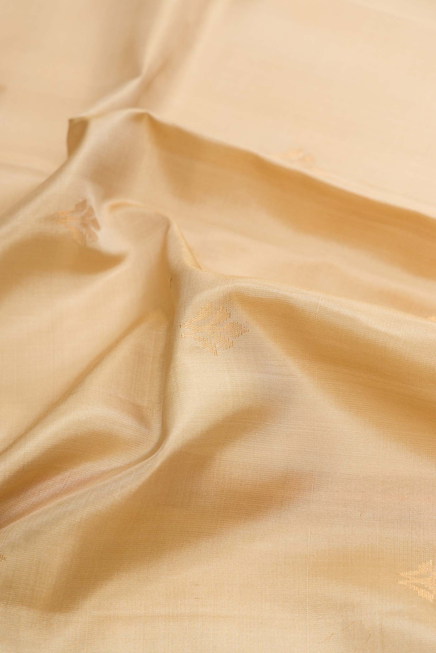 Close up of Beige Dual Tone Soft Silk Saree with Zari Butta on the body and Zari Border displaying folds