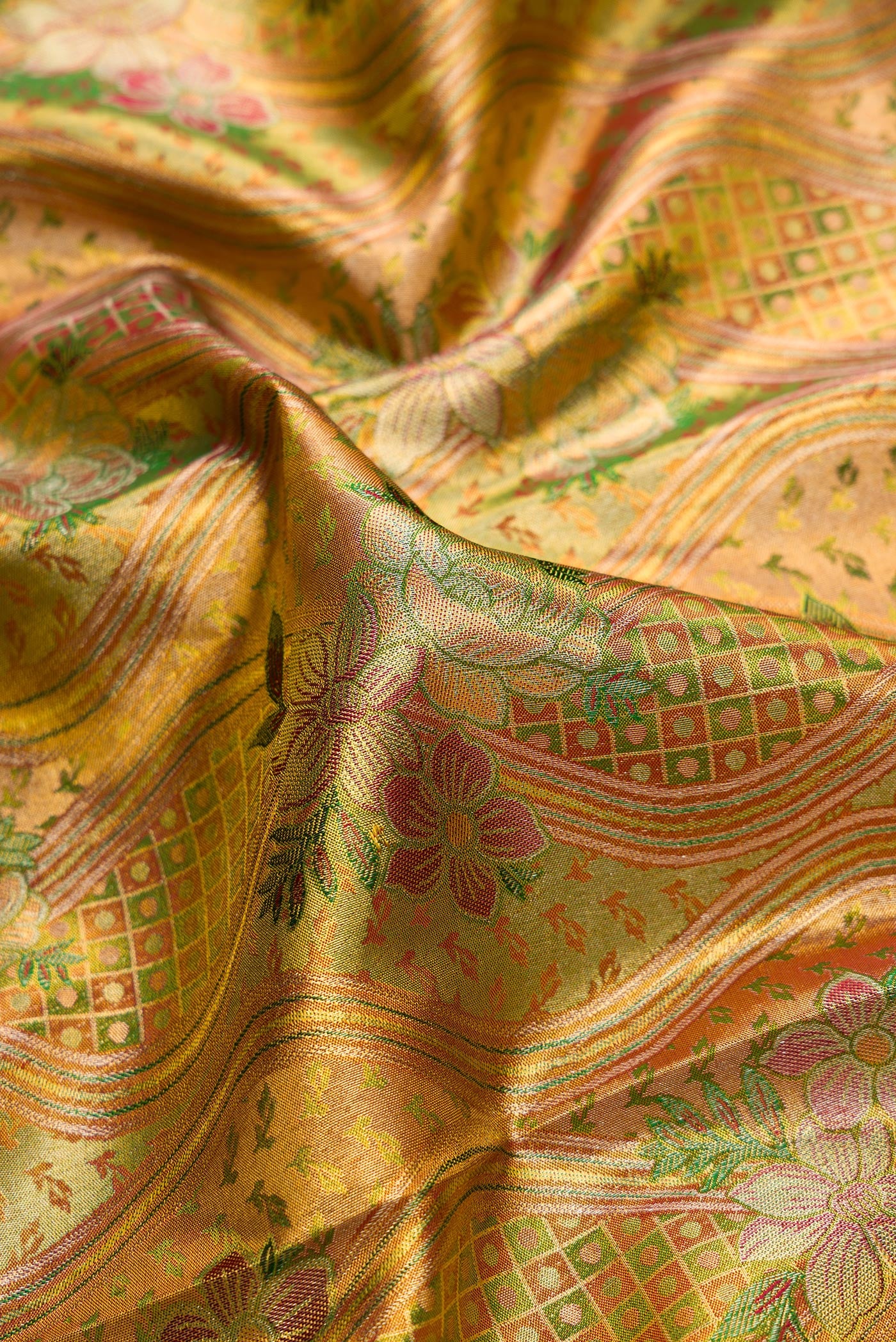 Close up of Gold Dual Tone Kanjivaram Tissue Silk Saree with Zari Brocade on the body and Zari Border.  displaying folds
