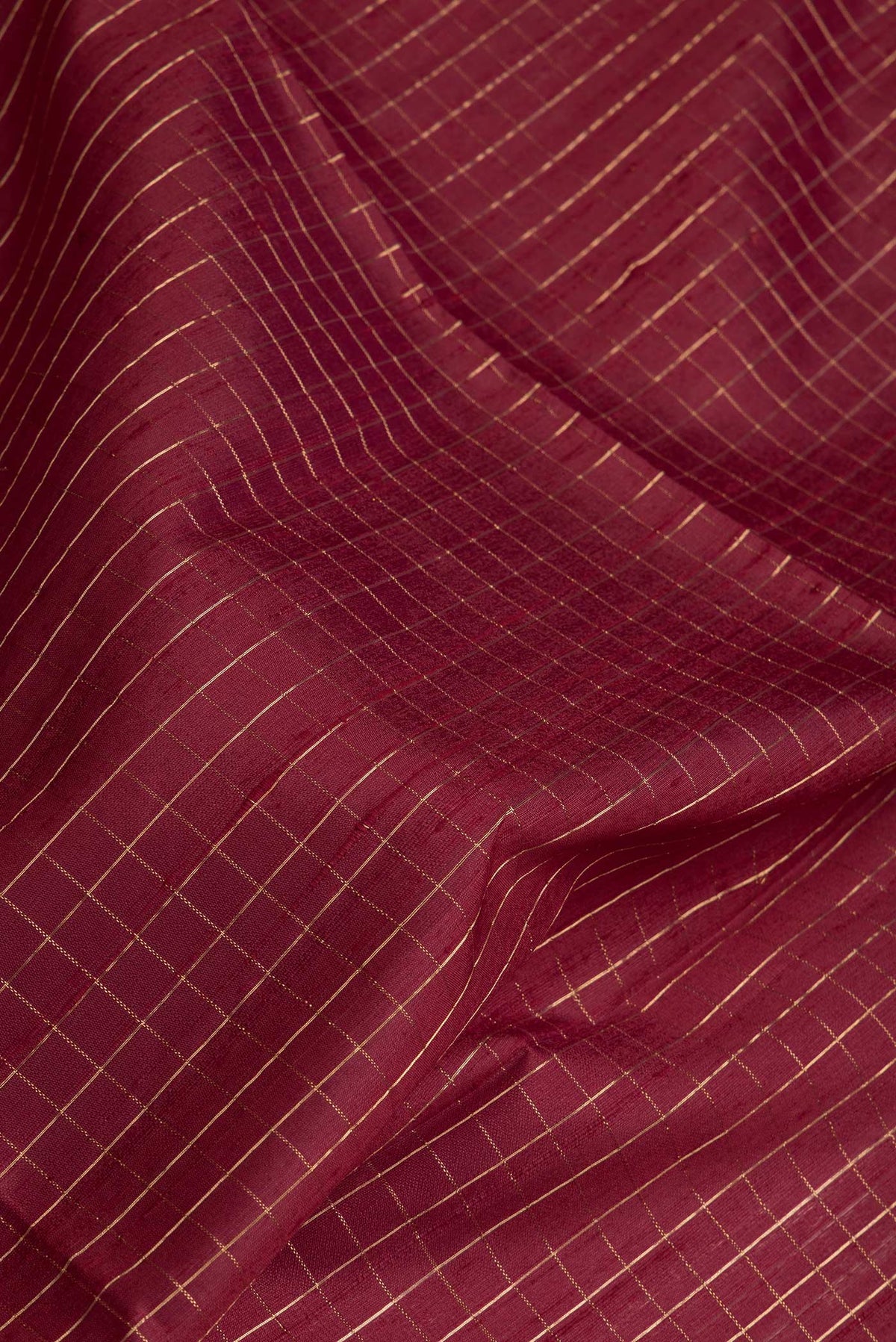 Close up of Maroon Dual Tone Raw Silk Saree with Checked design on the body and Thin Zari Line.  displaying folds