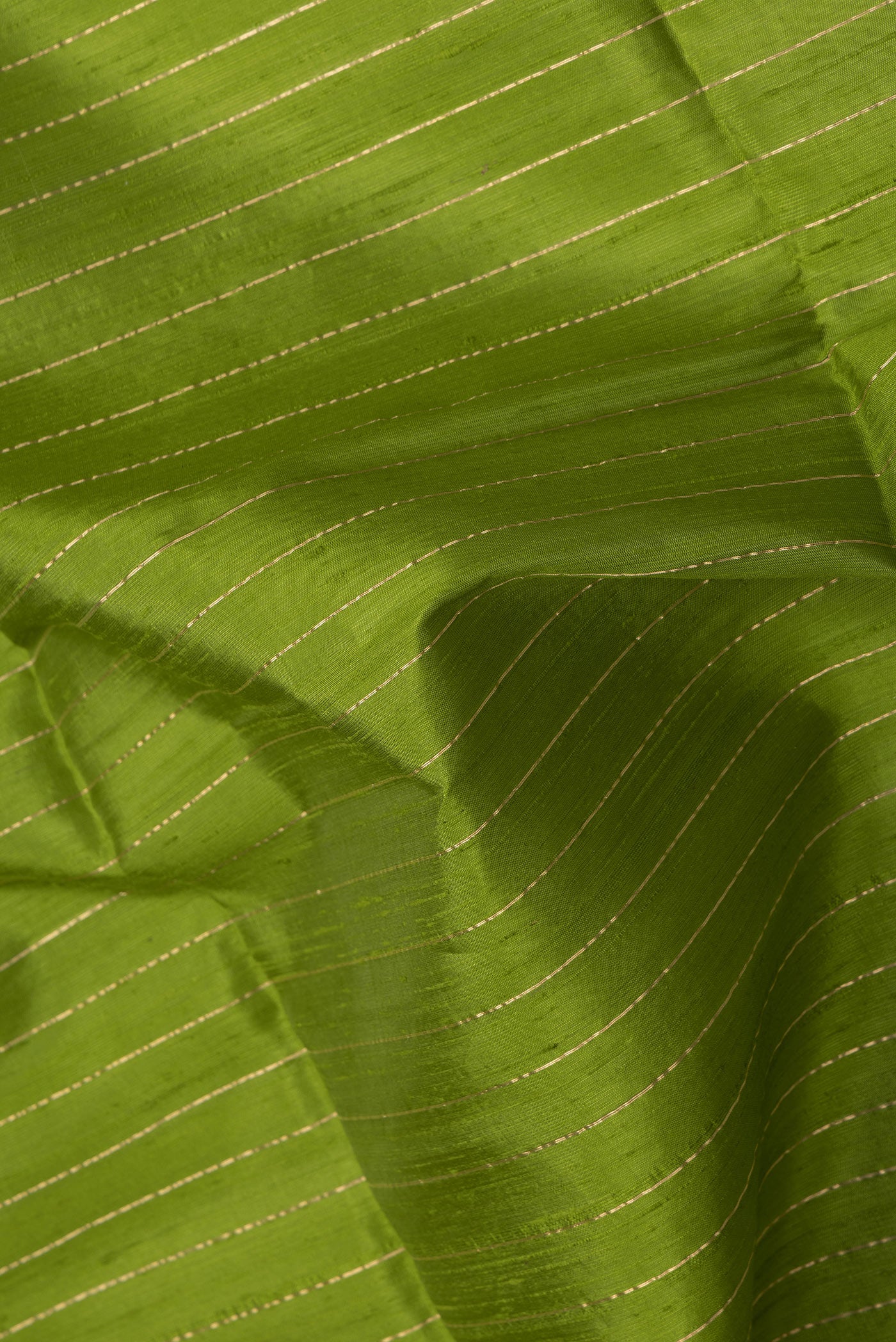 Close up of Green Dual Tone Raw Silk Saree with Stripes on the body and Temple Border.  displaying folds