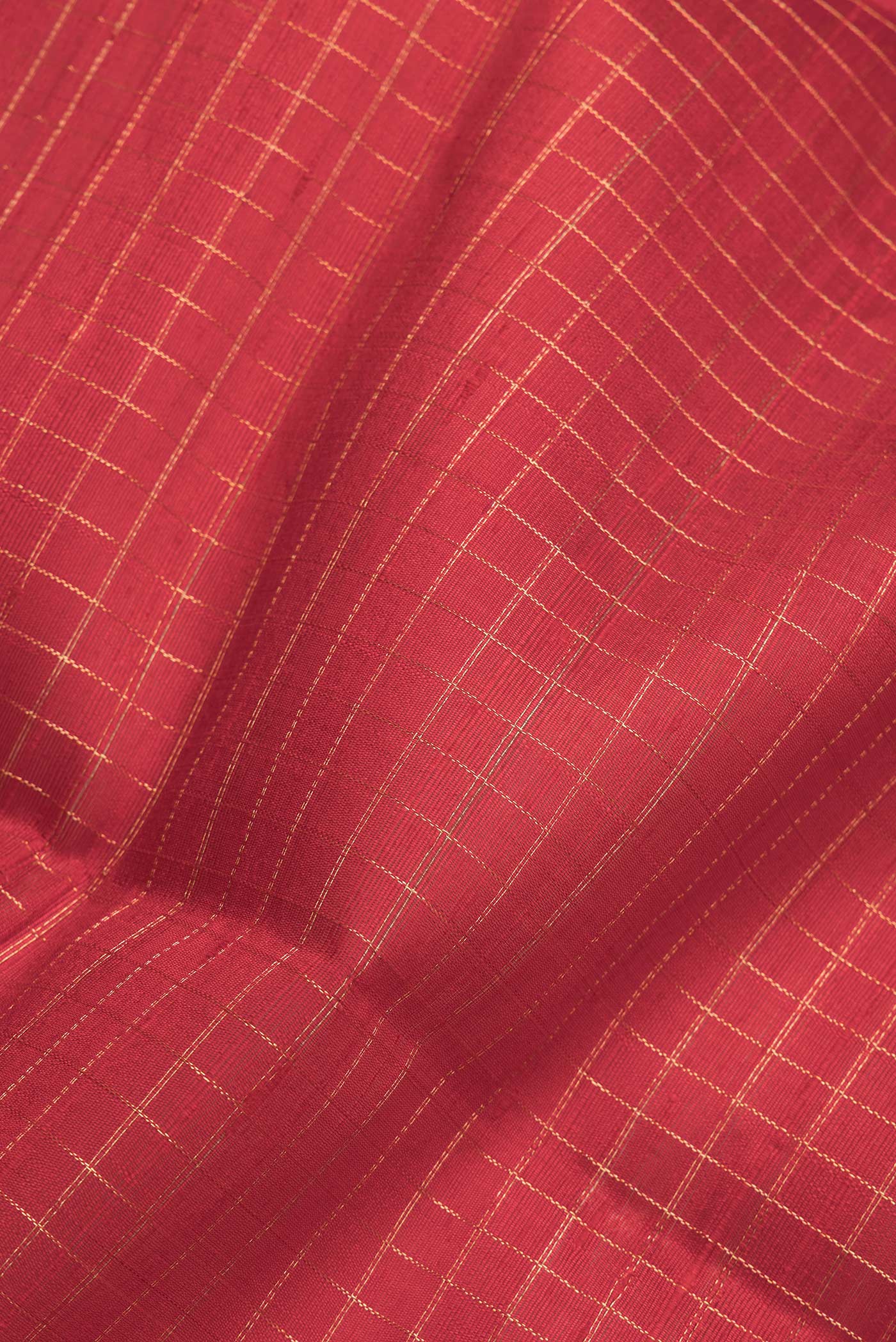 Close up of Red Dual Tone Raw Silk Saree with Checked design on the body and Zari Border.  displaying folds