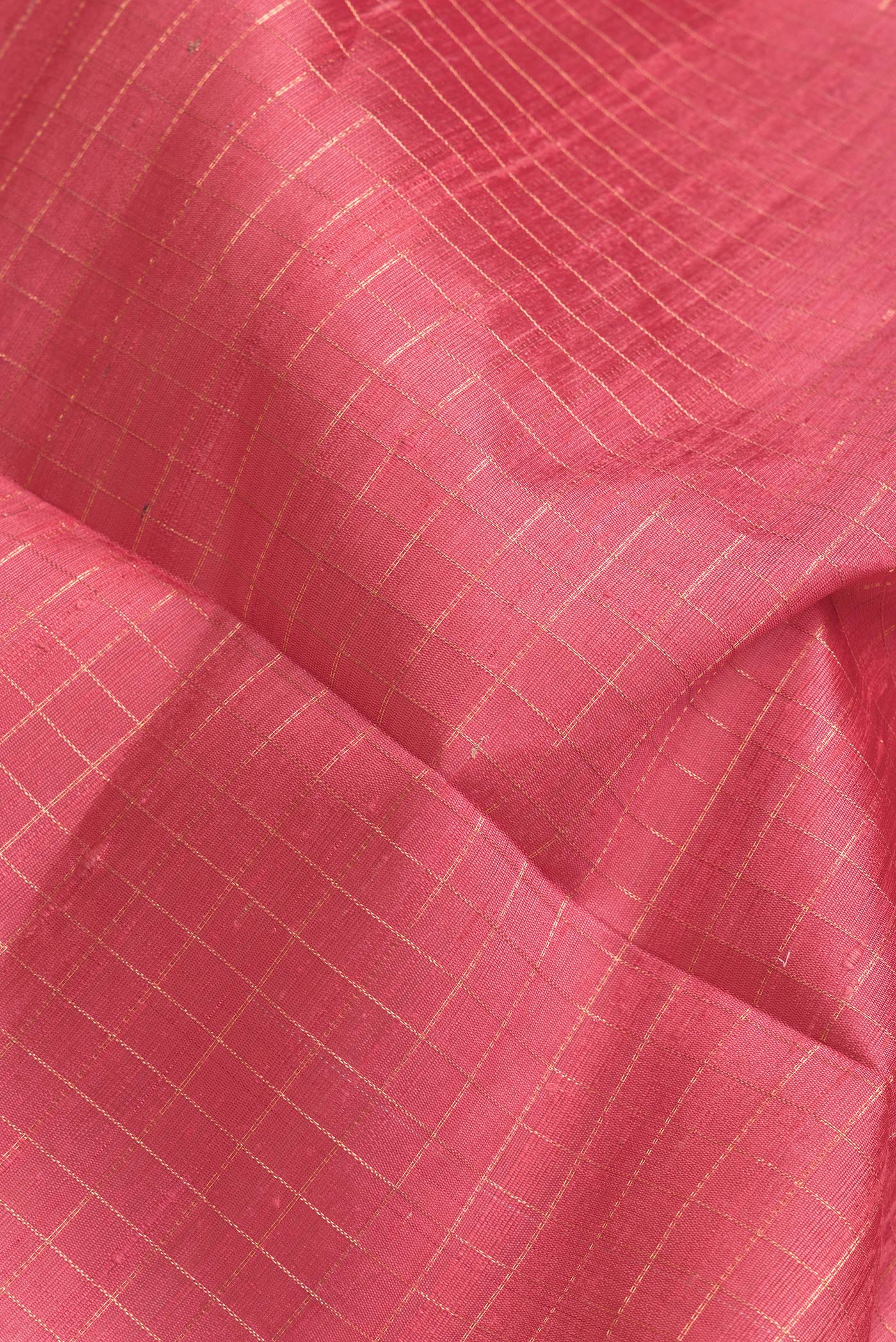 Close up of Pink Dual Tone Raw Silk Saree with Checked design on the body and Zari Border.  displaying folds