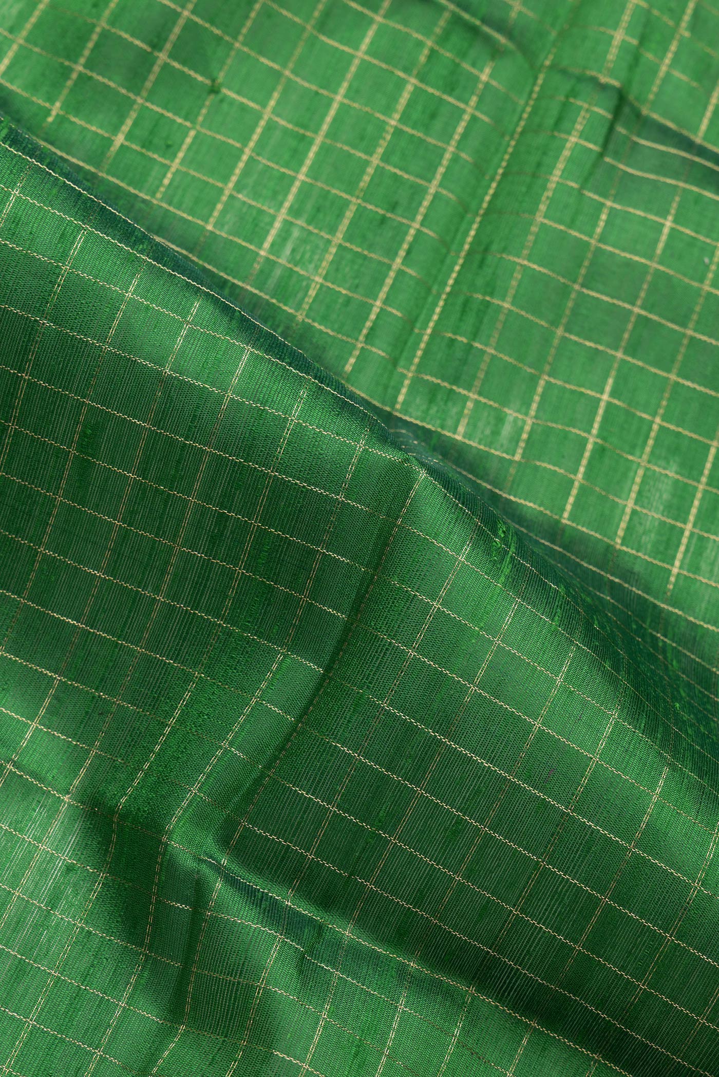 Close up of Green Dual Tone Raw Silk Saree with Checked design on the body and Zari Border.  displaying folds