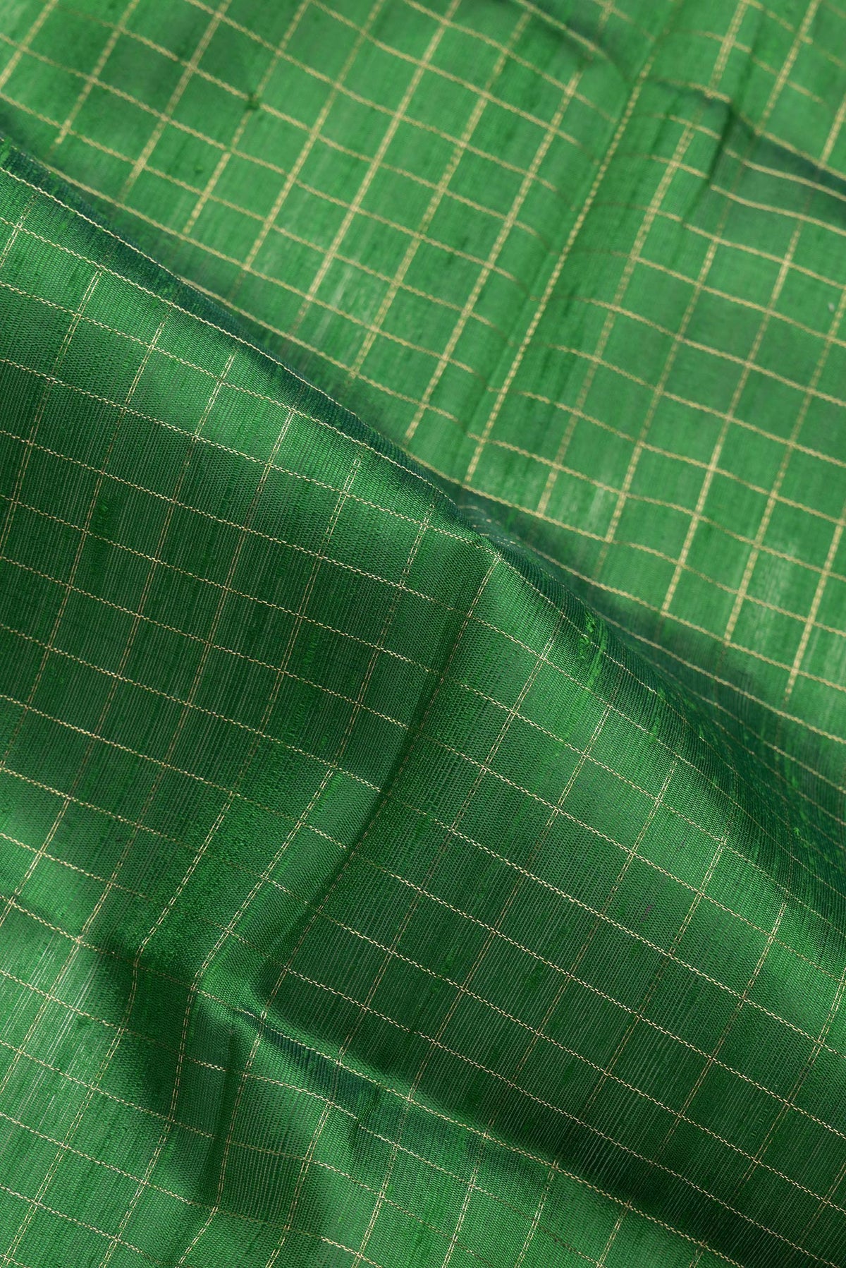 Close up of Green Dual Tone Raw Silk Saree with Checked design on the body and Zari Border.  displaying folds