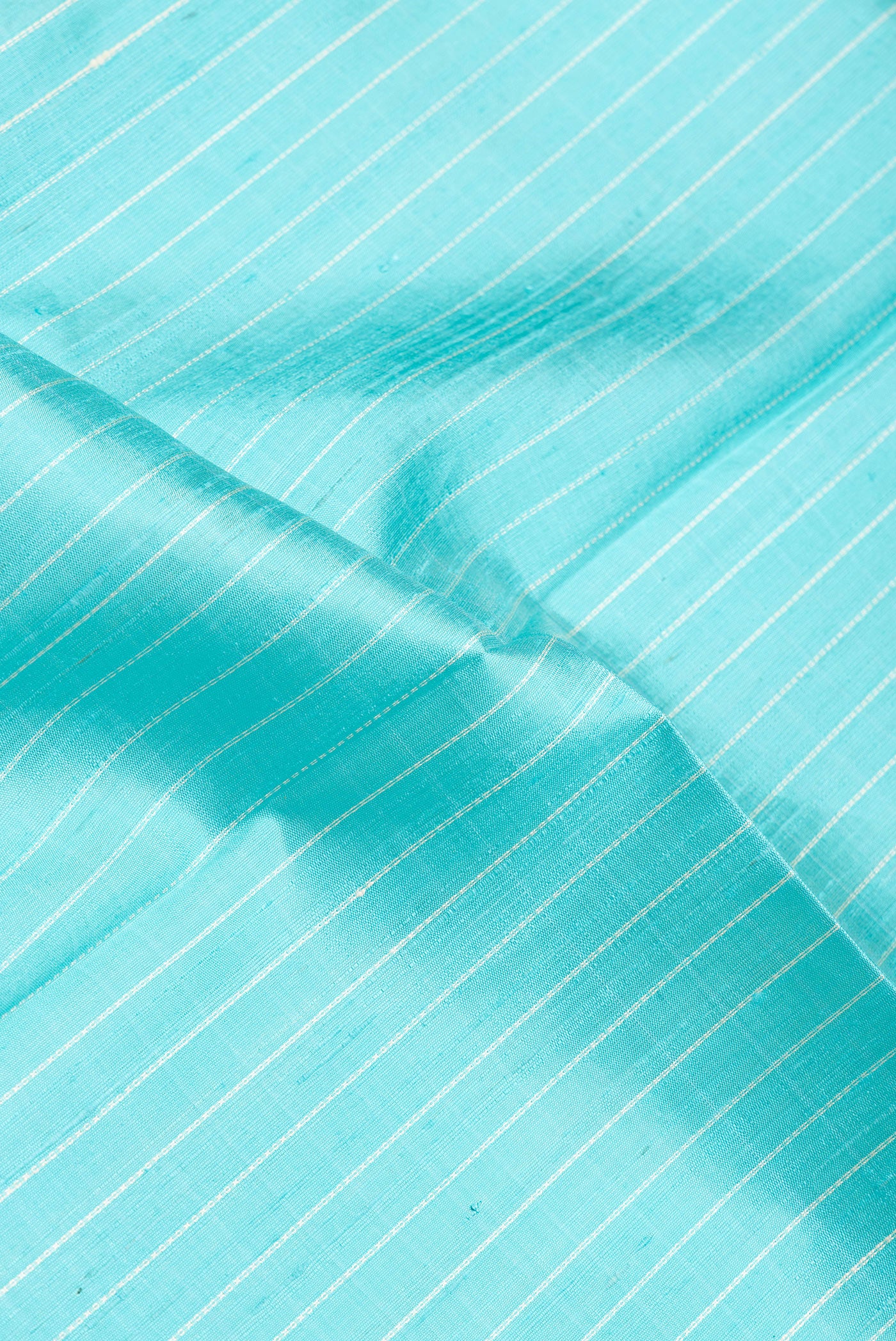 Close up of Sky Blue Dual Tone Raw Silk Saree with Stripes on the body and Thin Zari Line.  displaying folds