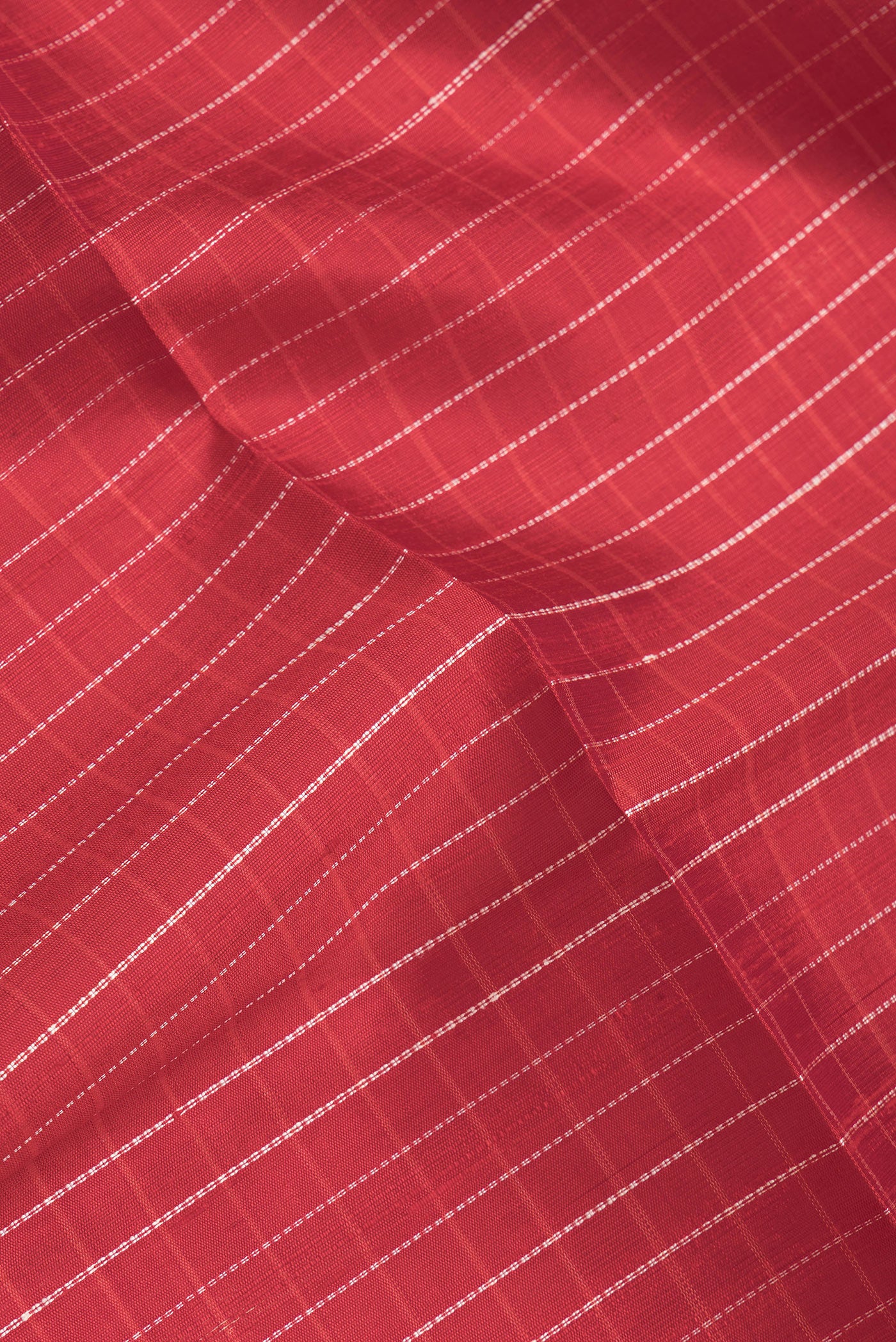 Close up of Red Dual Tone Raw Silk Saree with Checked design on the body and Zari Border.  displaying folds