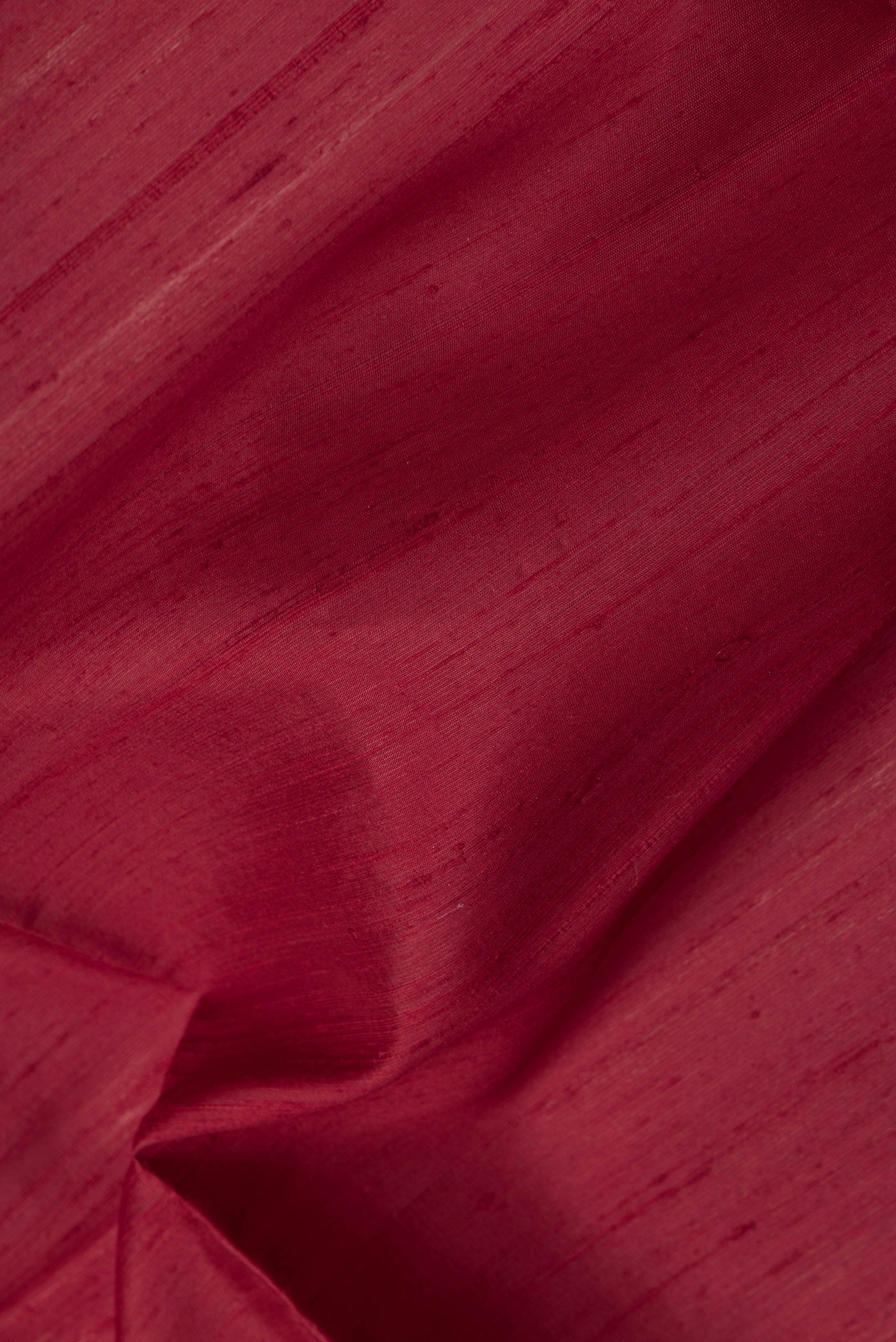 Close up of Maroon Dual Tone Raw Silk Saree with Plain Body and Thin Zari Line.  displaying folds