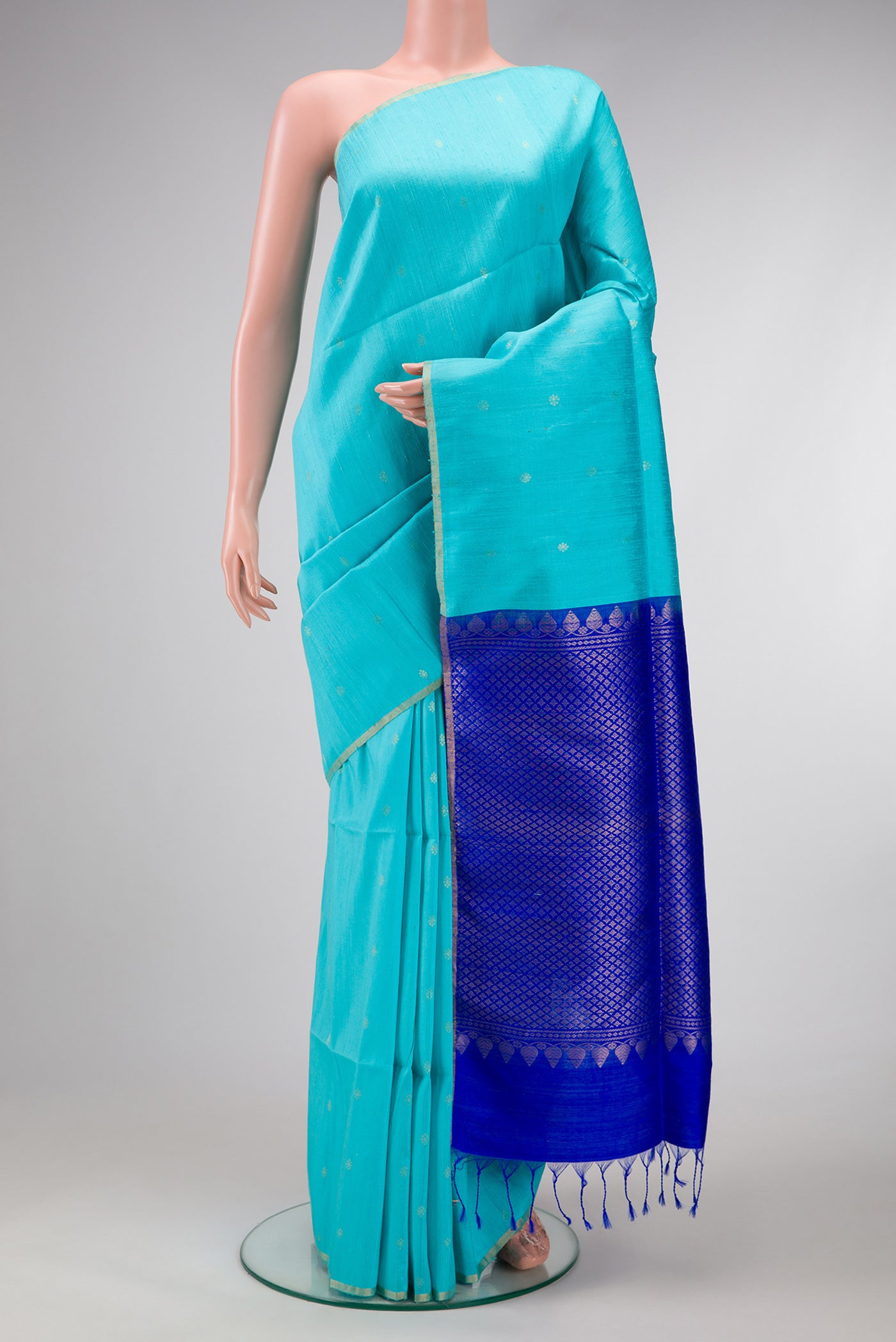 Sky Blue Dual Tone Raw Silk Saree with Zari Butta on the body and Thin Zari Line.  displayed on a mannequin