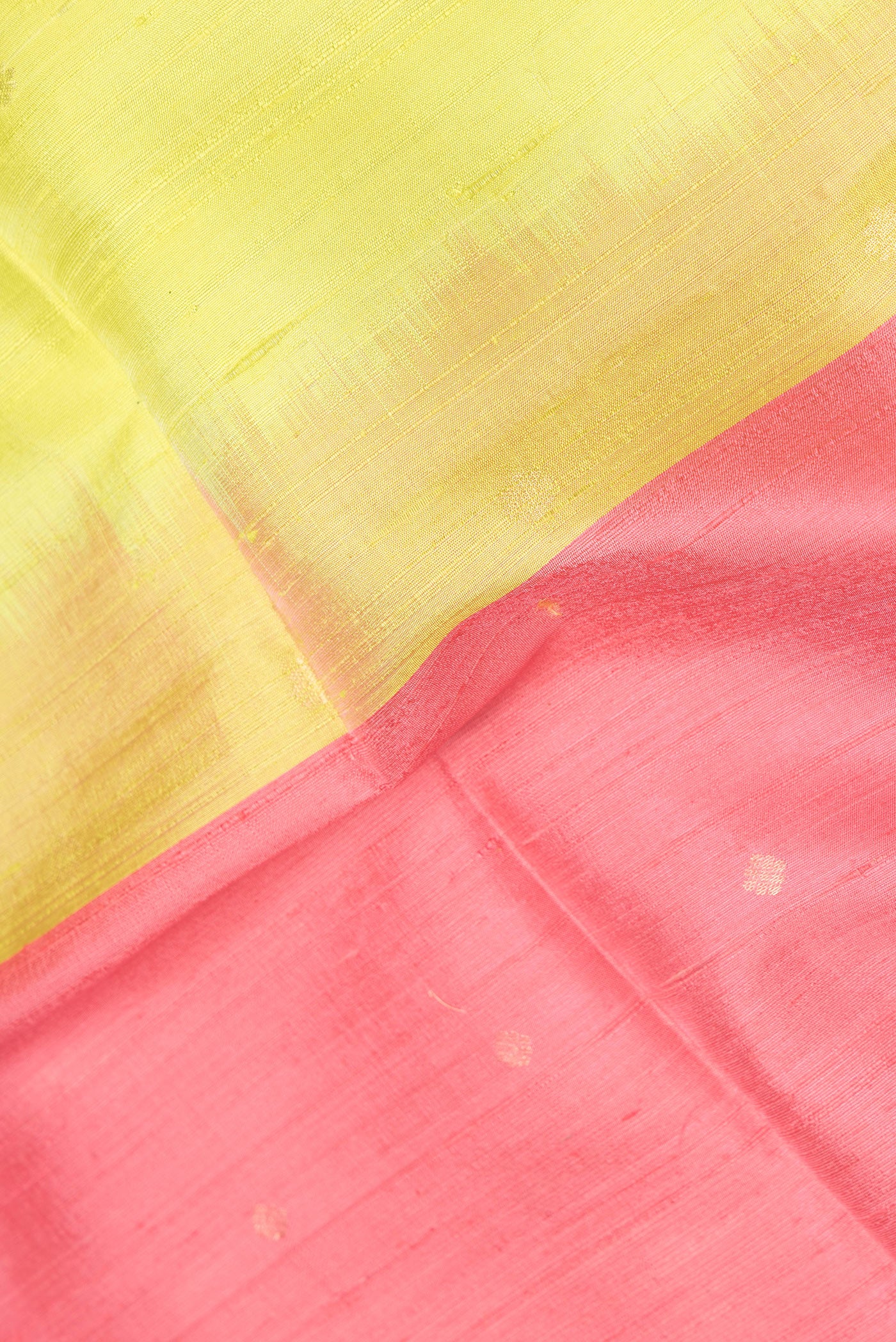 Close up of Pink Dual Tone Raw Silk Saree with Thread Butta on the body and Thin Zari Line.  displaying folds