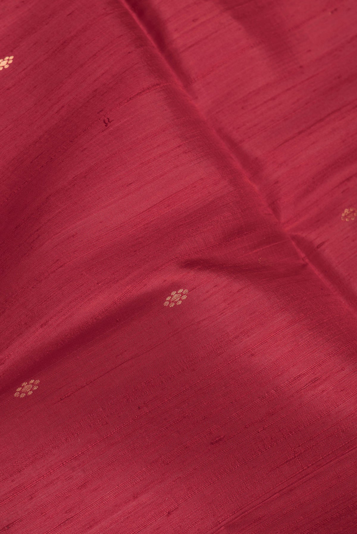 Close up of Maroon Dual Tone Raw Silk Saree with Zari Butta on the body and Fancy Border.  displaying folds