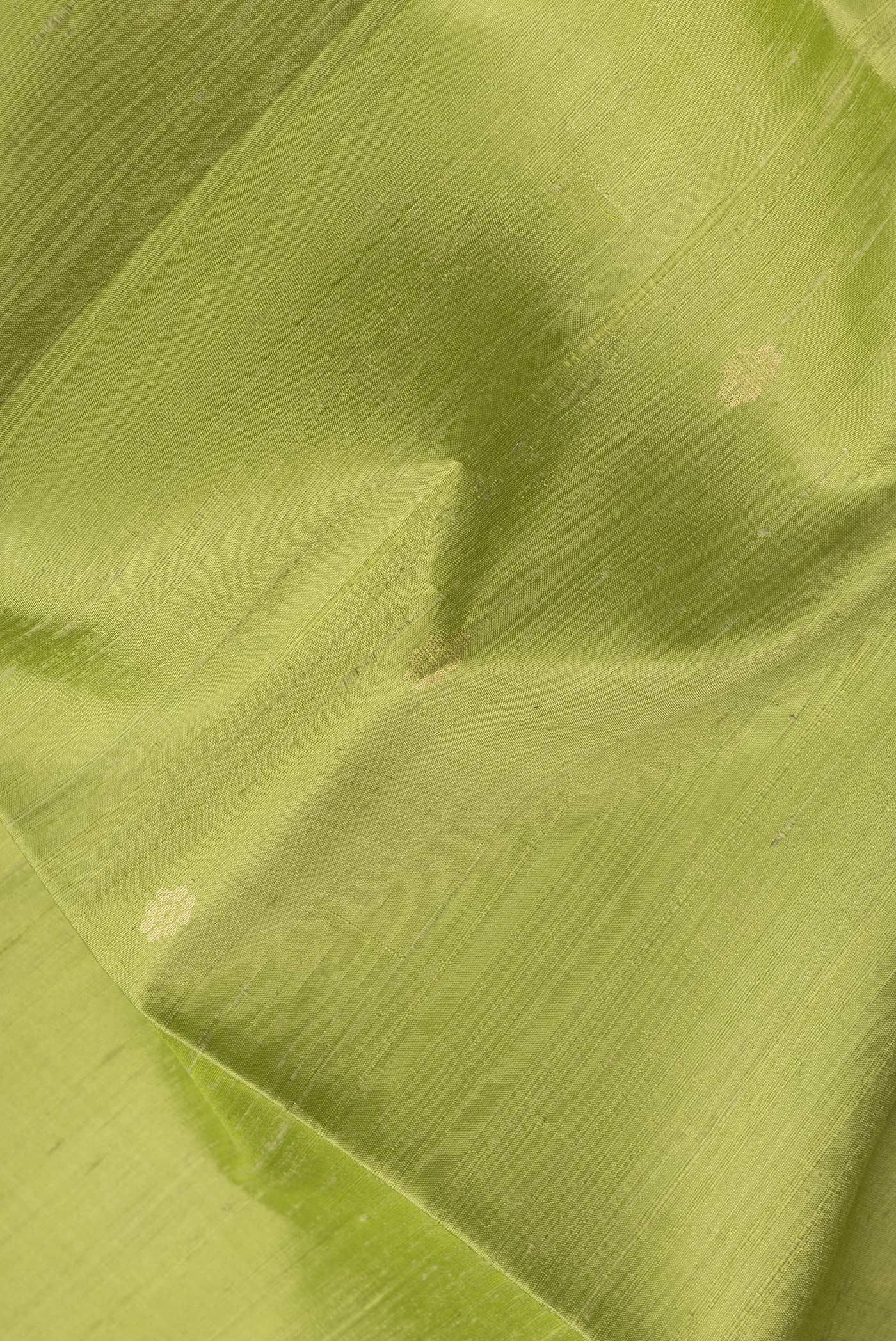 Close up of Parrot Green Dual Tone Raw Silk Saree with Zari Butta on the body and Fancy Border.  displaying folds