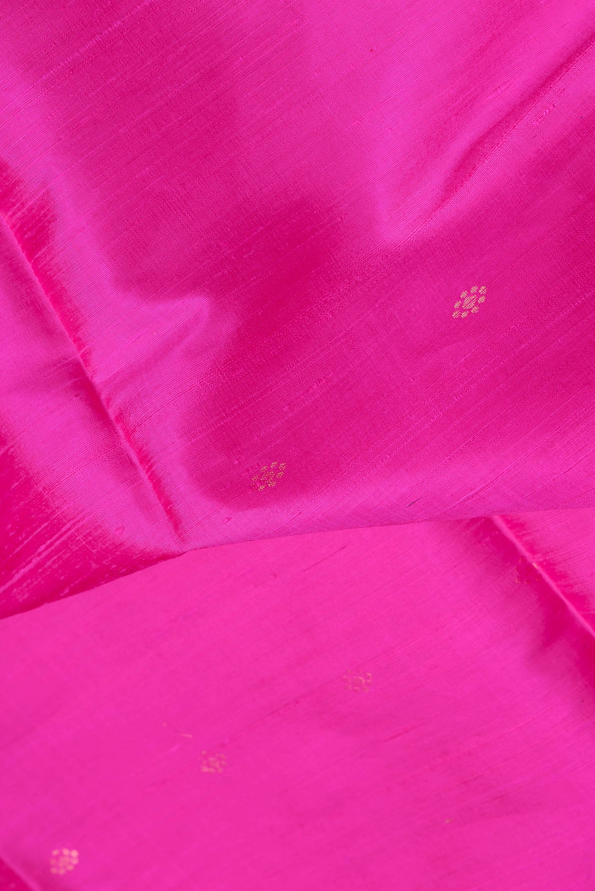 Close up of Dark Pink Dual Tone Raw Silk Saree with Zari Butta on the body and Fancy Border.  displaying folds